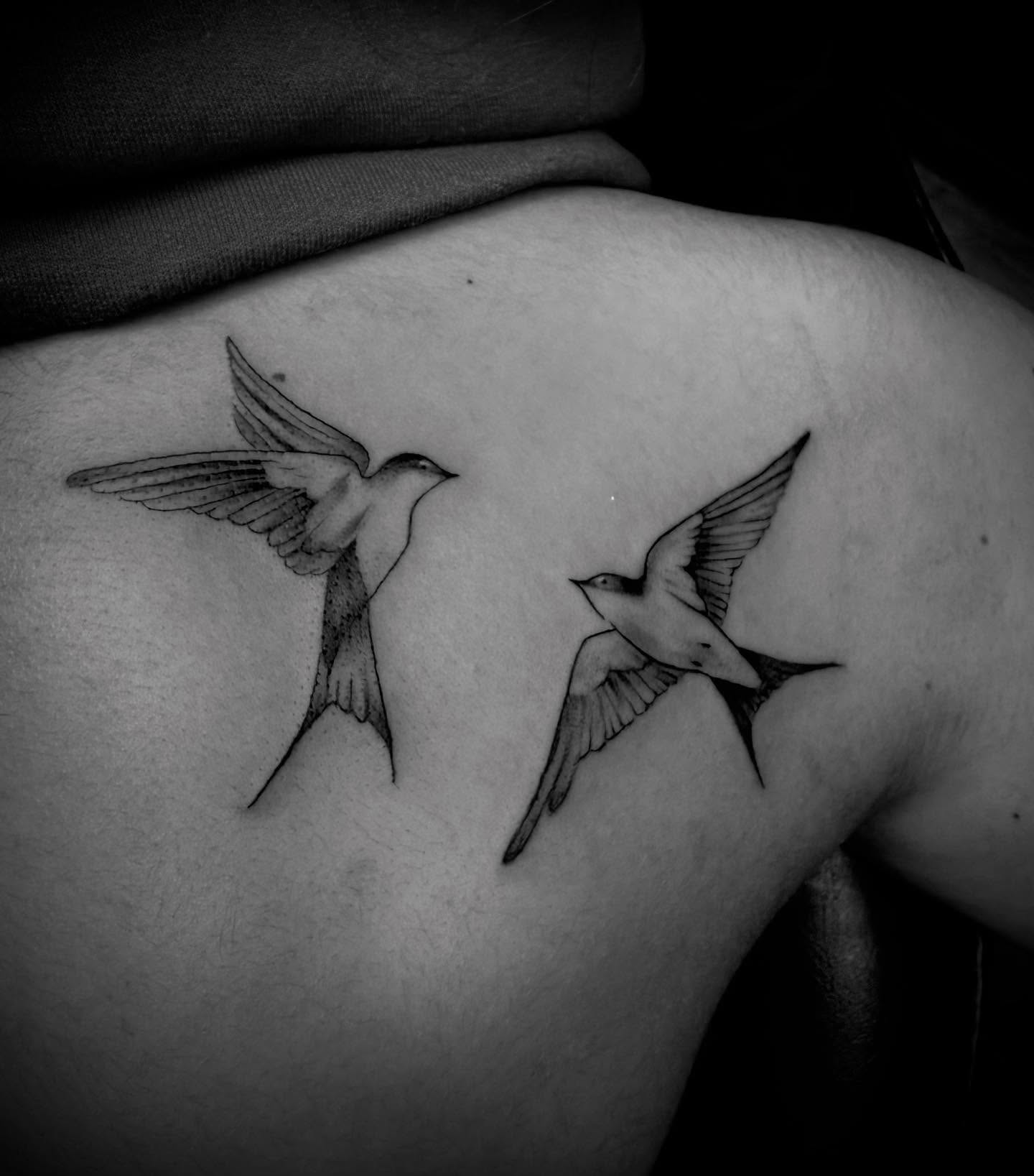 Swallows black and grey tattoo on the shoulder by Jameson William Cowan