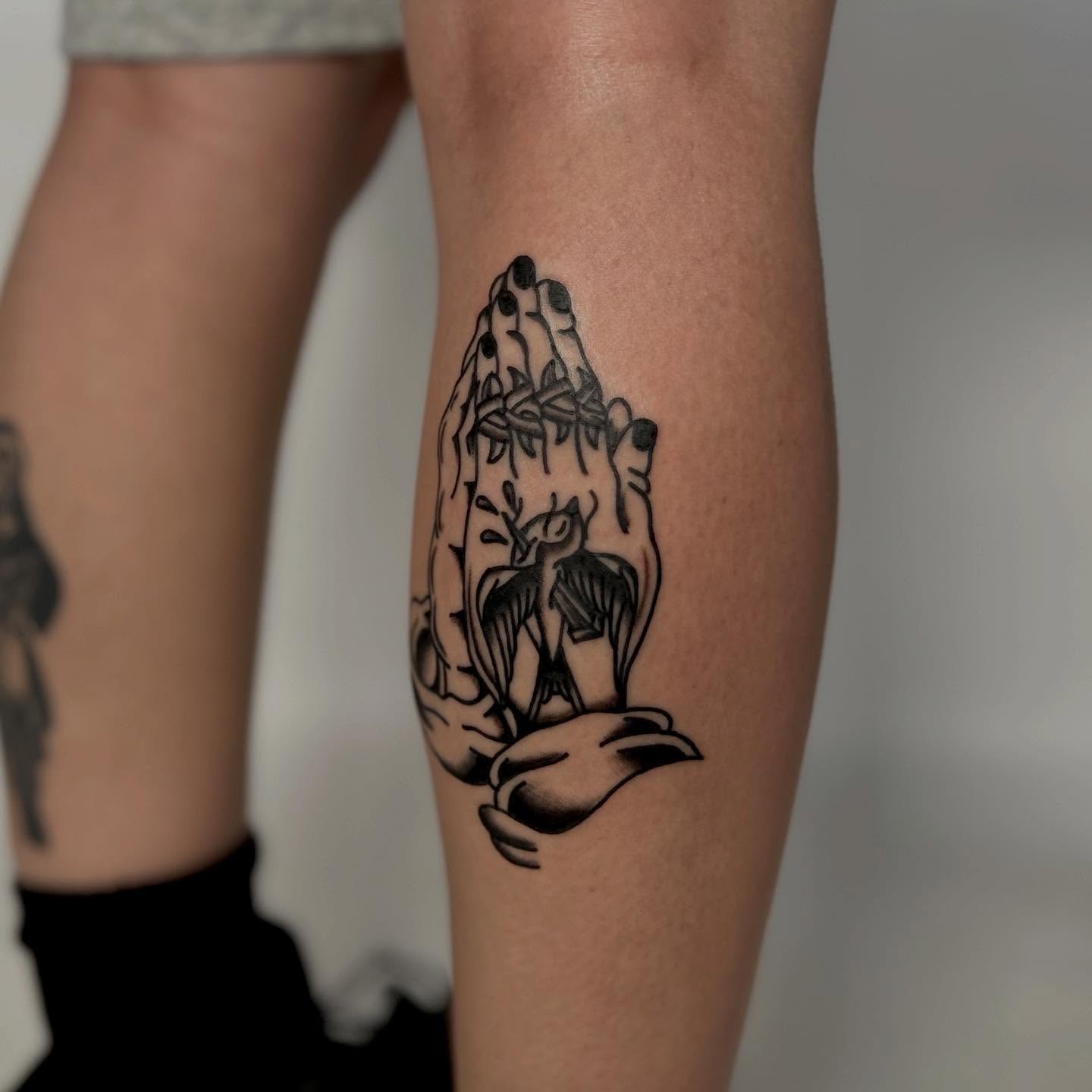 Praying hands with bird black and grey tattoo on the forearm by Lip™