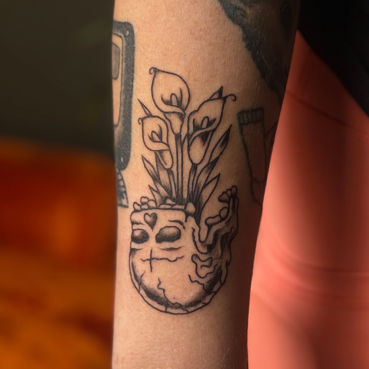 Calla lilies and skull black and grey tattoo on the forearm by Béle Benard