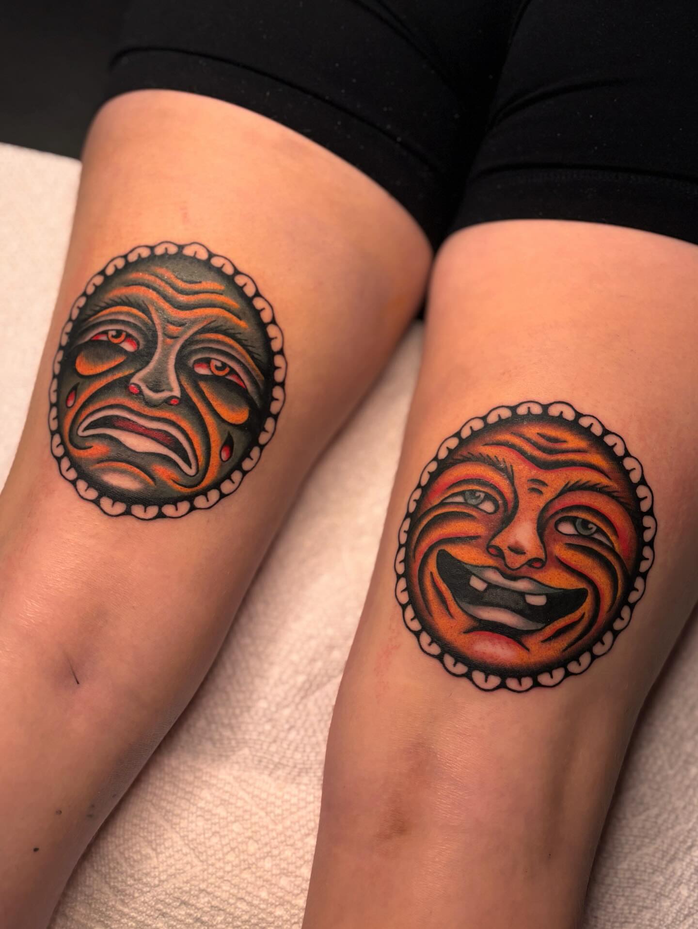 Theater masks American traditional tattoo on the thigh by Jesse Smith, Chicago, Illinois