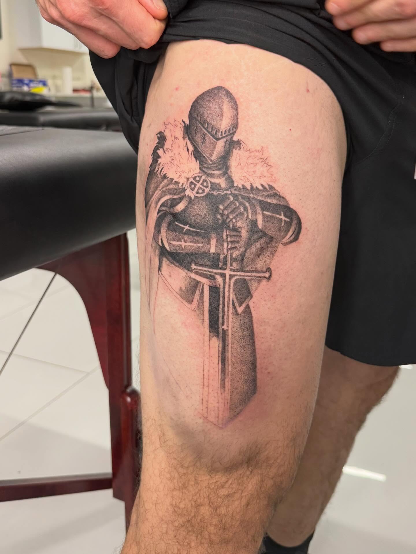 Knight in armor black and grey tattoo on the thigh by Andrew Flatts