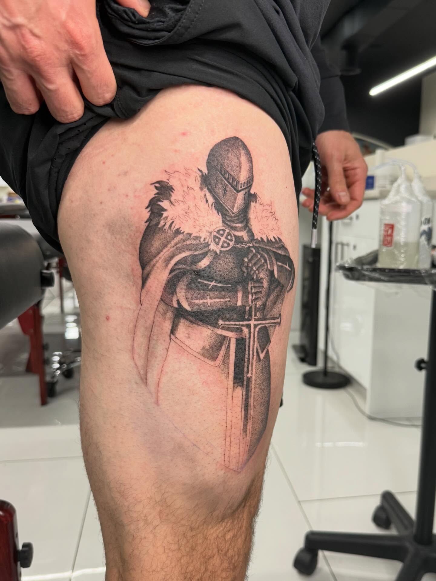 Knight black and grey tattoo on the thigh by Andrew Flatts