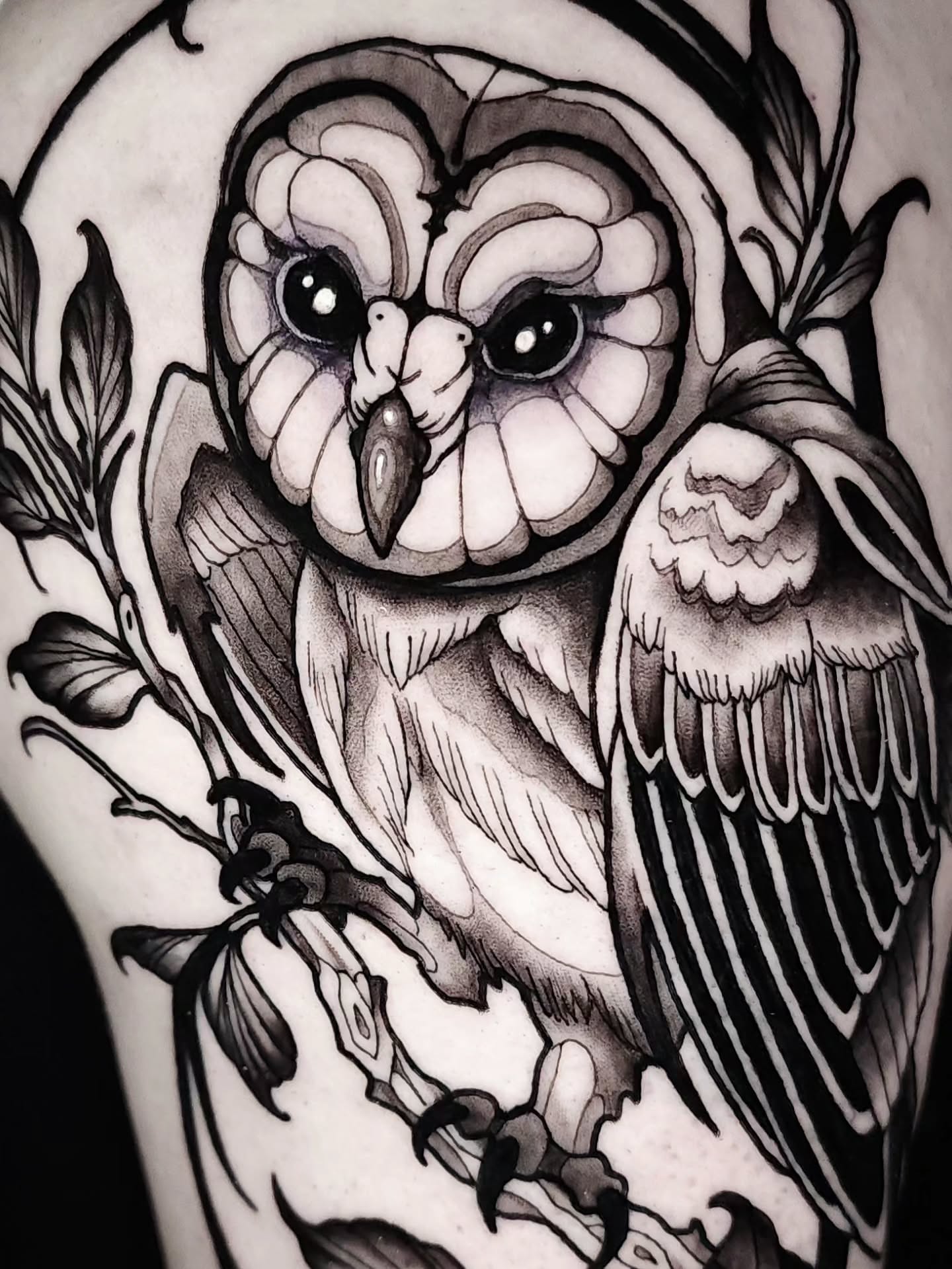 Owl black and grey tattoo on the upper arm by Mario Romero