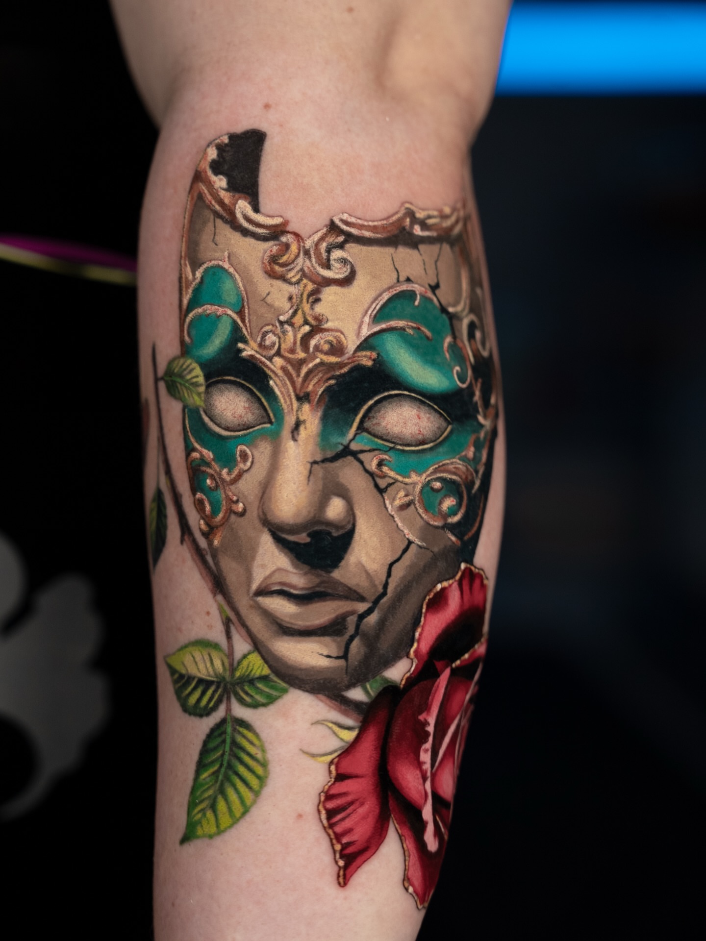 Mask and rose realism tattoo on the forearm by Natalie Shaw