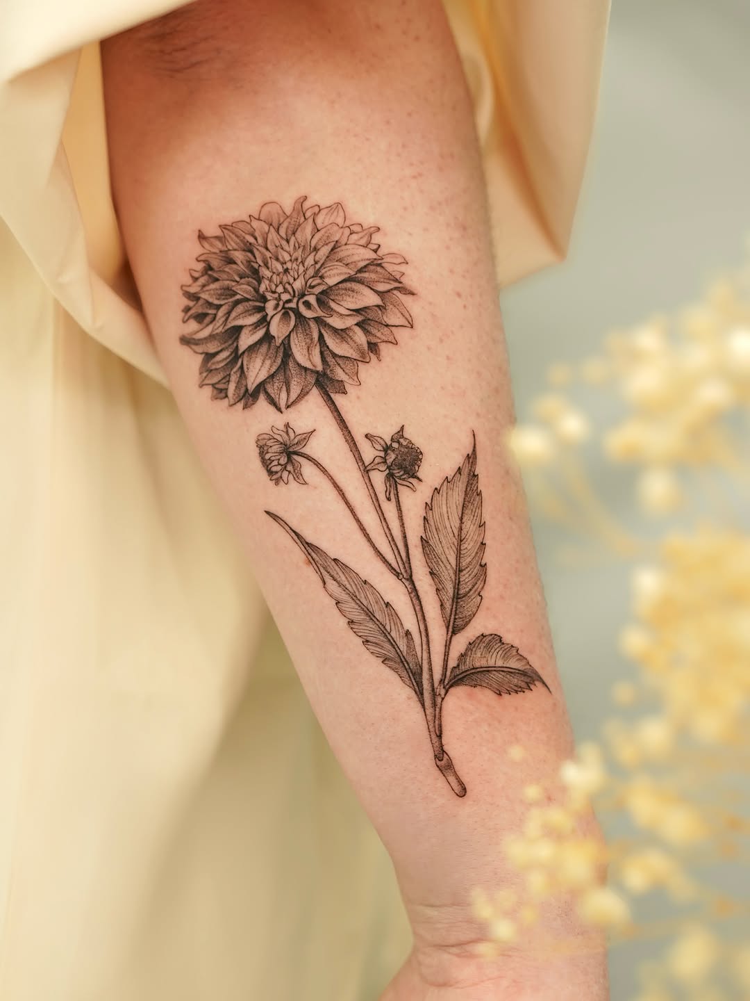 Dahlia flower fine line tattoo on the forearm by Valentina