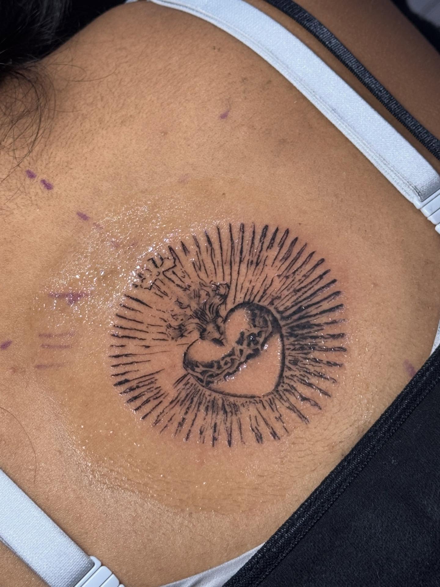 Heart with rays black and grey tattoo on the back by Nat🫧