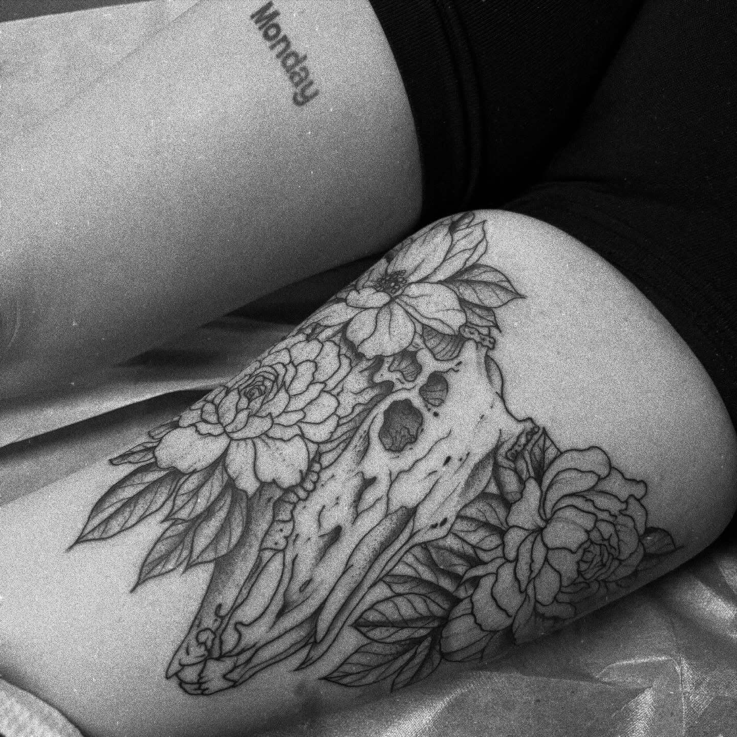 Skull with flowers realism tattoo on the thigh by 18 and older High End Tattoo