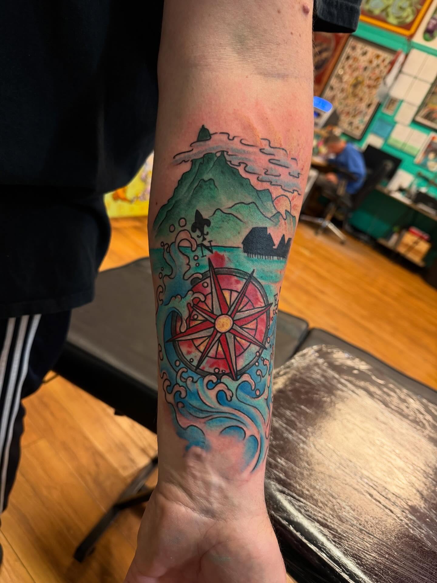 Compass and wave watercolor tattoo on the forearm by Madilynn Klassen
