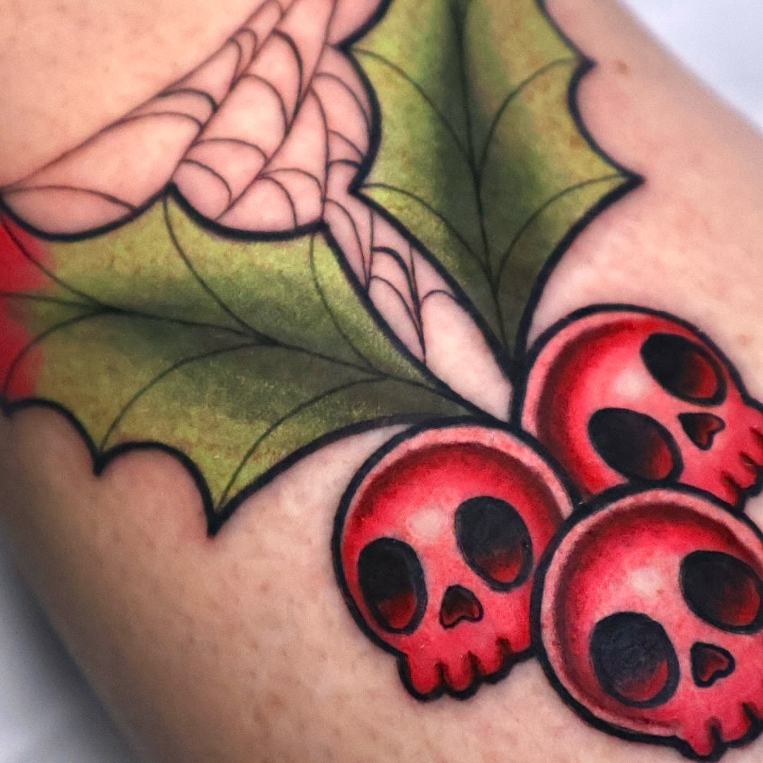Holly leaves and skulls American traditional tattoo on the forearm by Bailey Drey