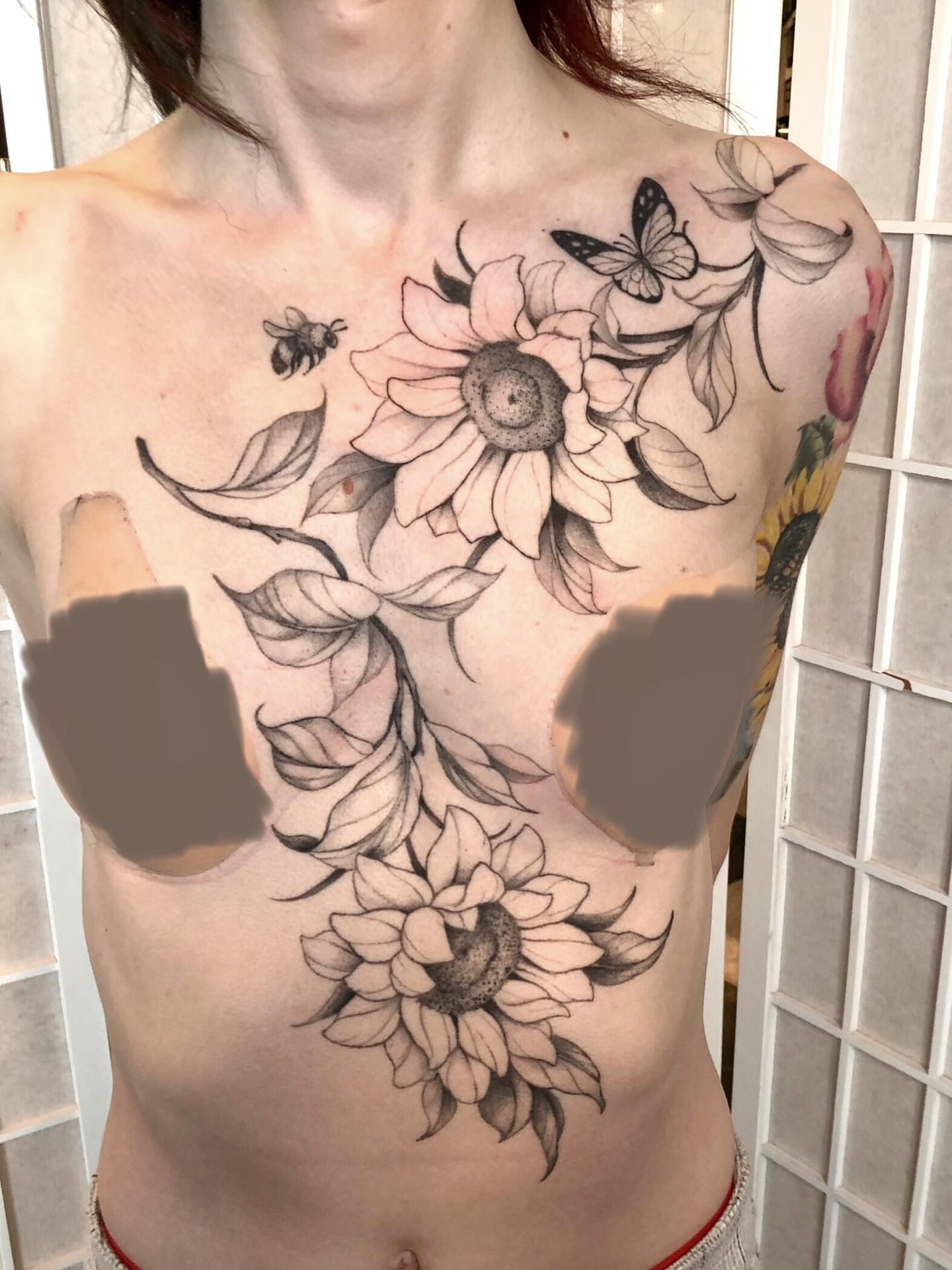 Sunflowers and butterfly black and grey tattoo on the chest by Leah Leinani