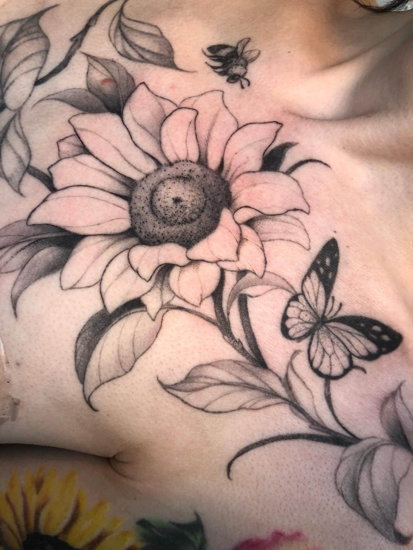 Sunflower and butterfly dotwork tattoo on the chest by Leah Leinani