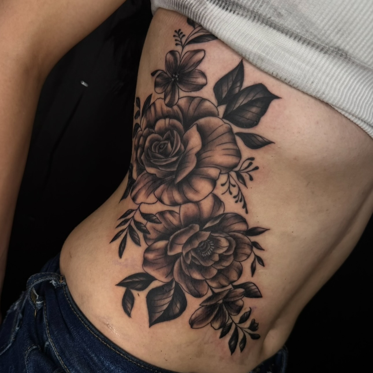 Flowers black and grey tattoo on the ribs by Elijah East