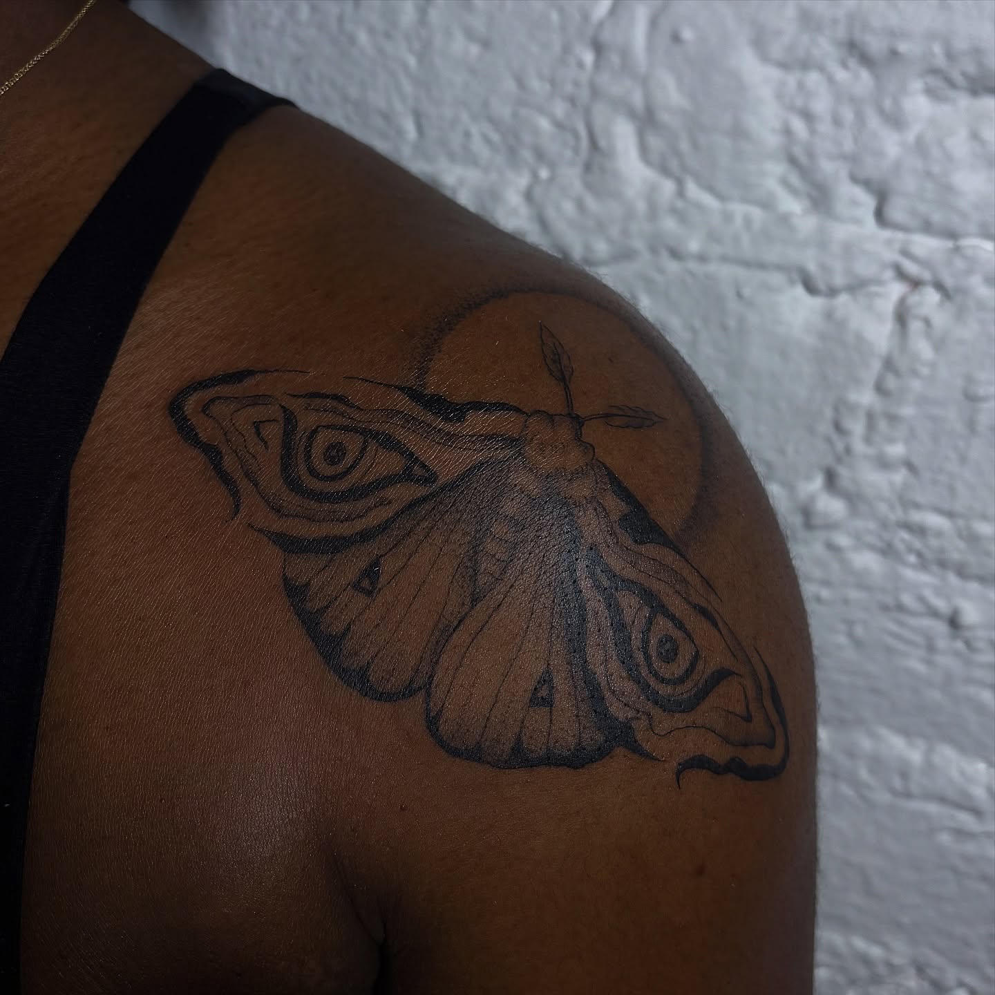 Moth black and grey tattoo on the shoulder by Sydney Gallucci
