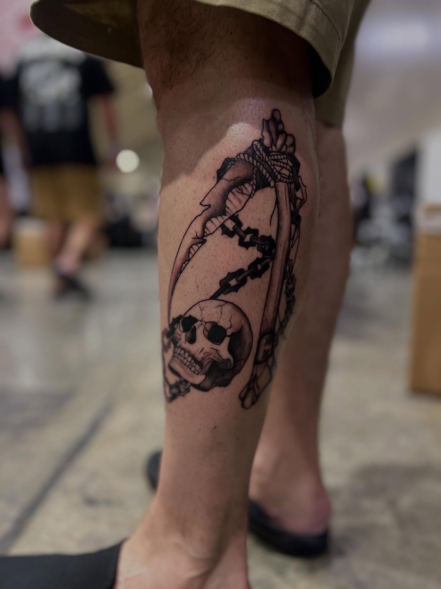 Skull and chains black and grey tattoo on the calf by Rebecca Kern Tattoos