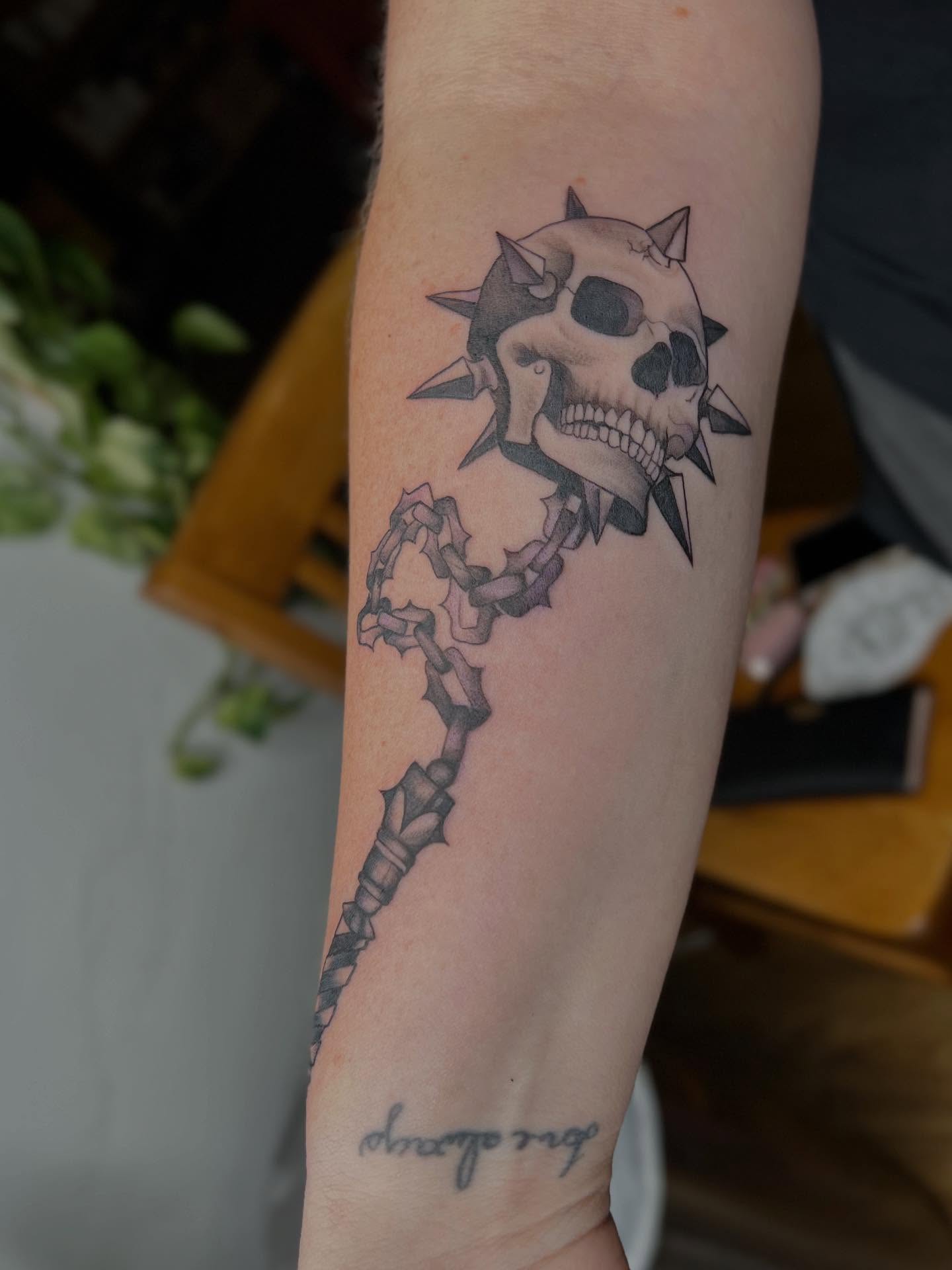 Skull and spiked mace realism tattoo on the forearm by Rebecca Kern Tattoos