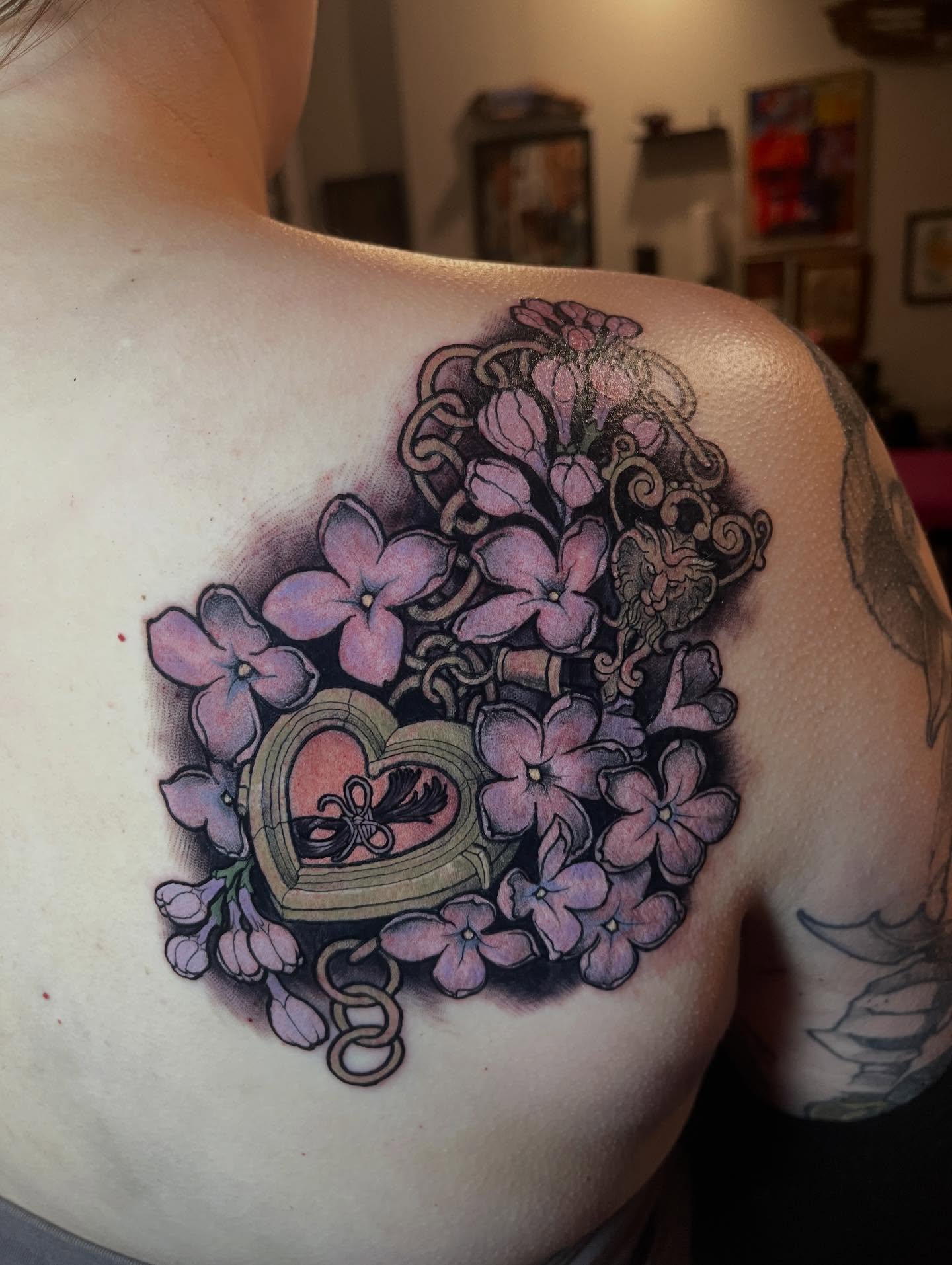 Lilacs and heart neo-traditional tattoo on the shoulder by Joe Moreira