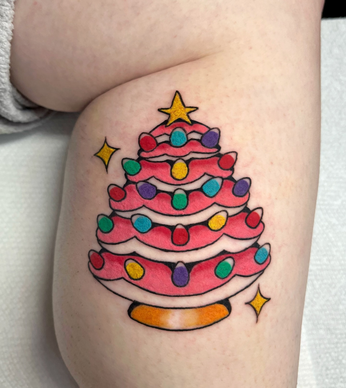 Christmas tree American traditional tattoo on the thigh by Alena McDonald