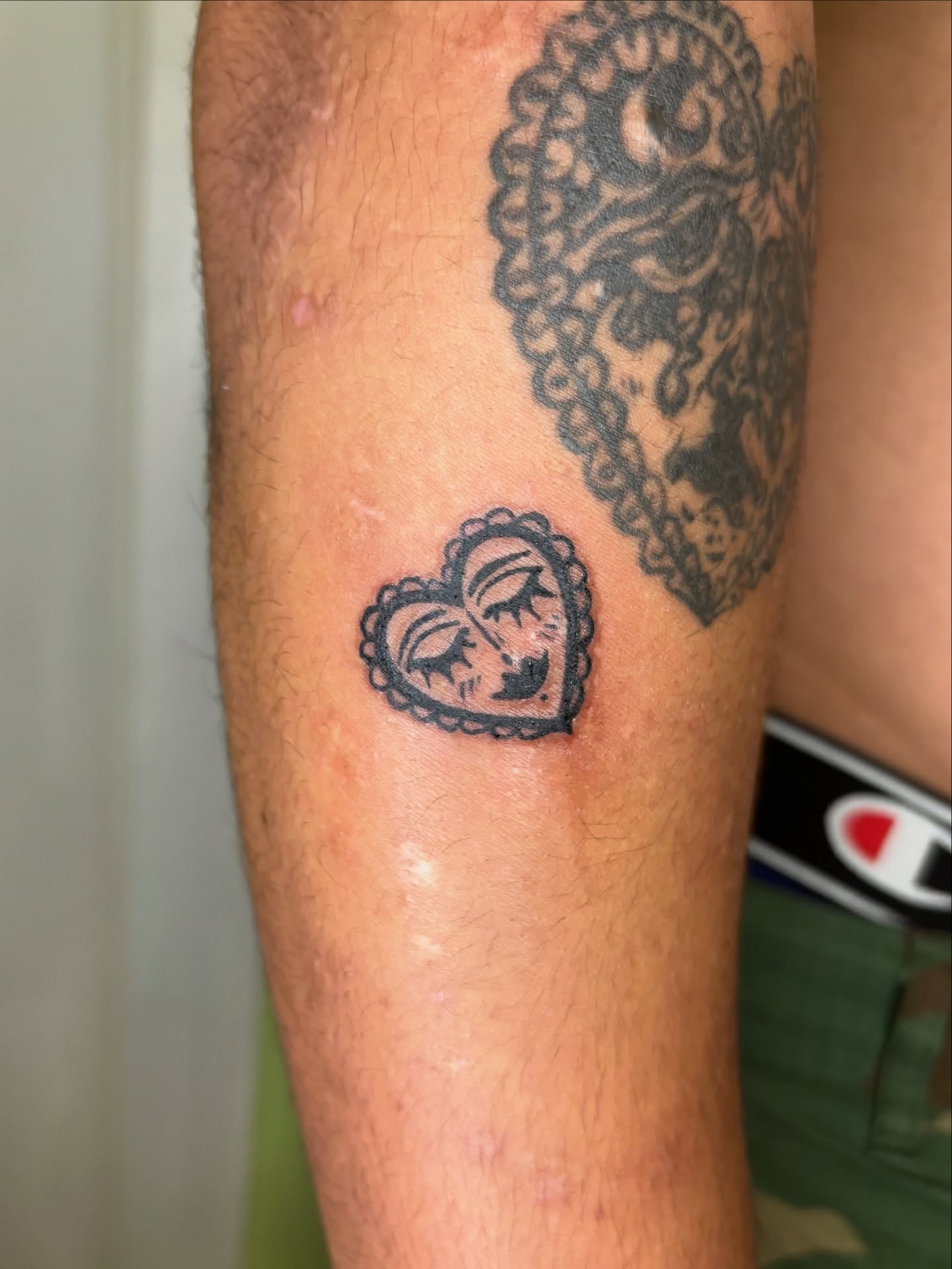 Heart with face black and grey tattoo on the forearm by Grae