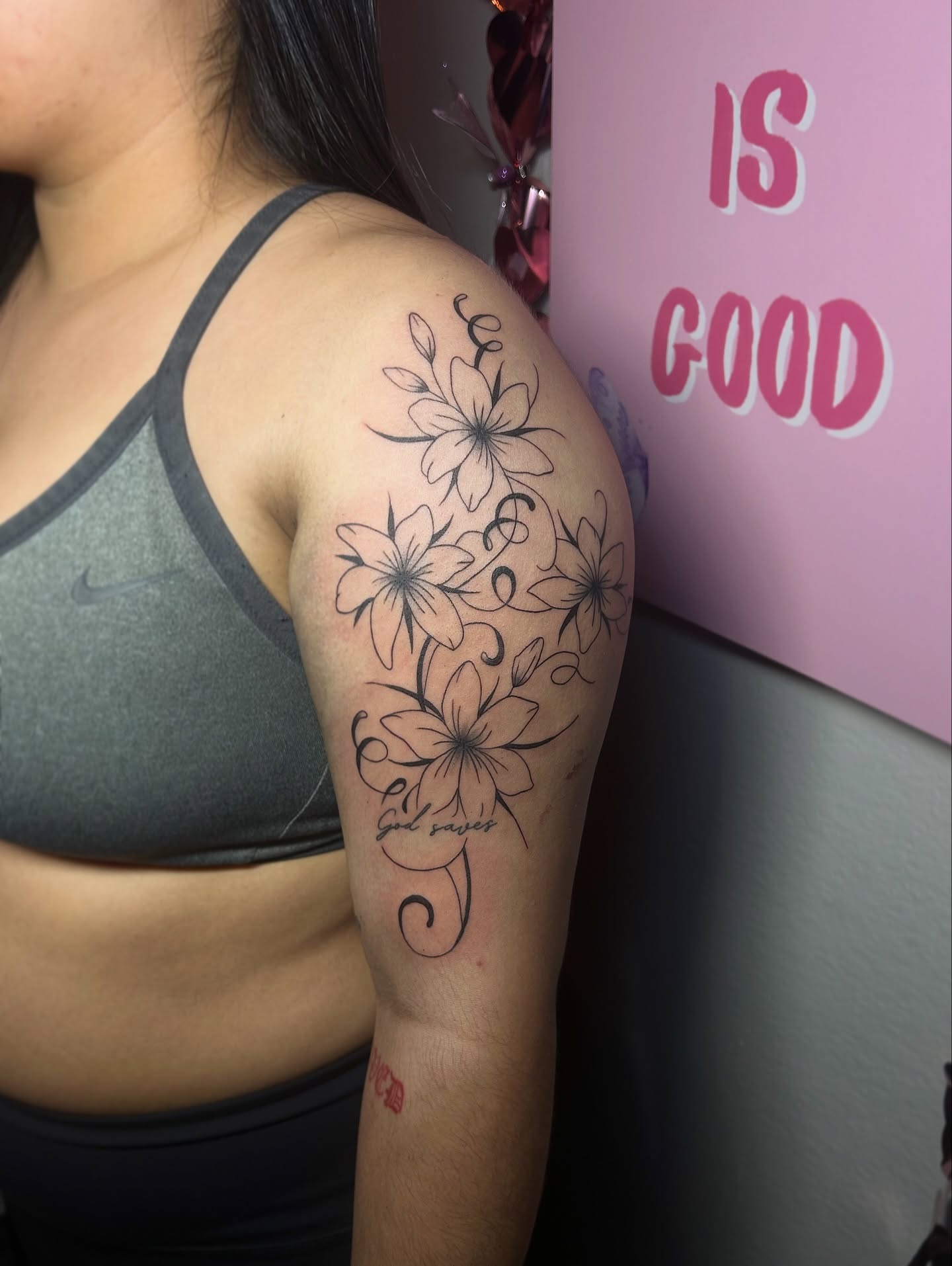 Lilies black and grey tattoo on the upper arm by @tattoosbyskyeee