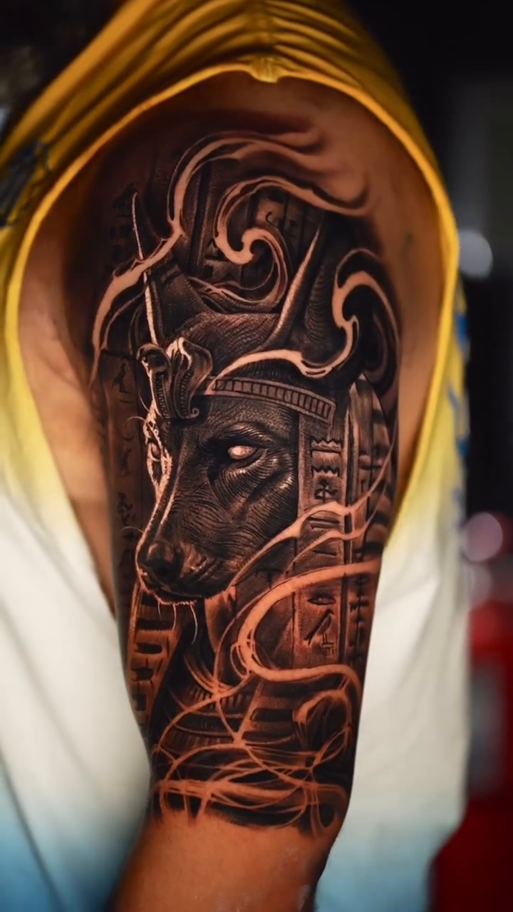 Egyptian jackal-headed deity dark realism tattoo by Tattoos By Chino