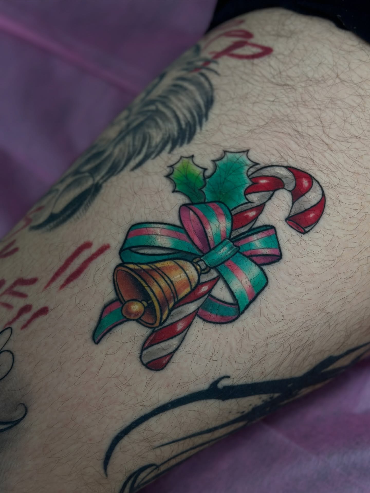 Candy cane and bell American traditional tattoo on the forearm by โ ๐ฟ๐๐ ๐ญ๐๐๐๐