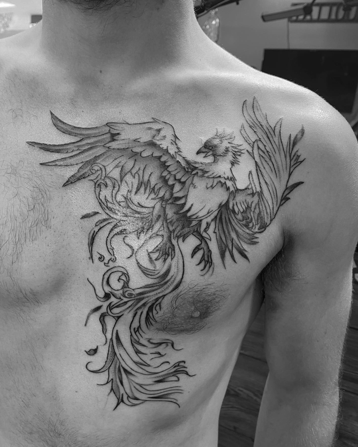 Phoenix black and grey tattoo on the chest by Spencer Jones Tattoos