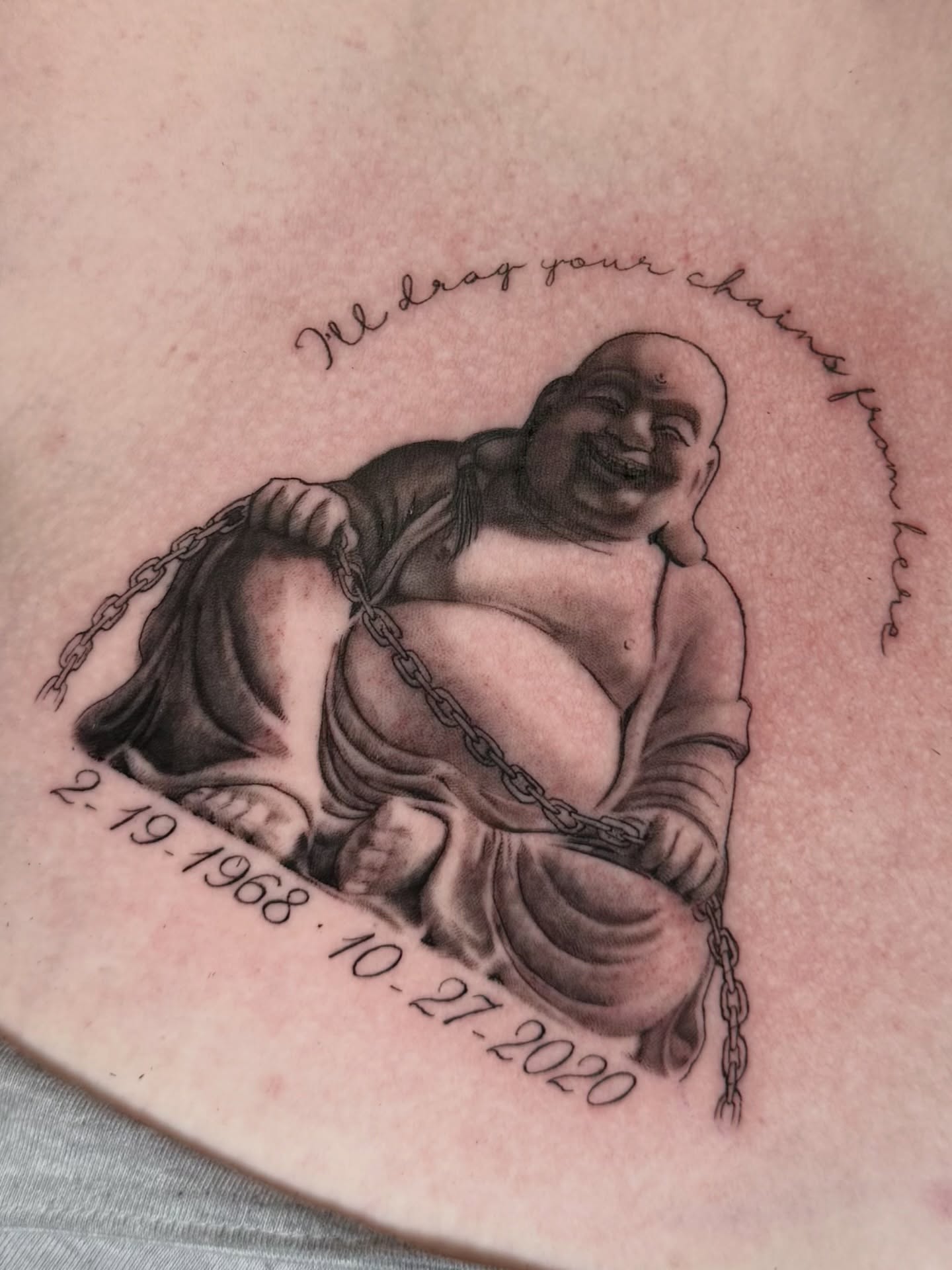 Smiling Buddha with chains black and grey tattoo on the torso by Gilberto Flores Nava