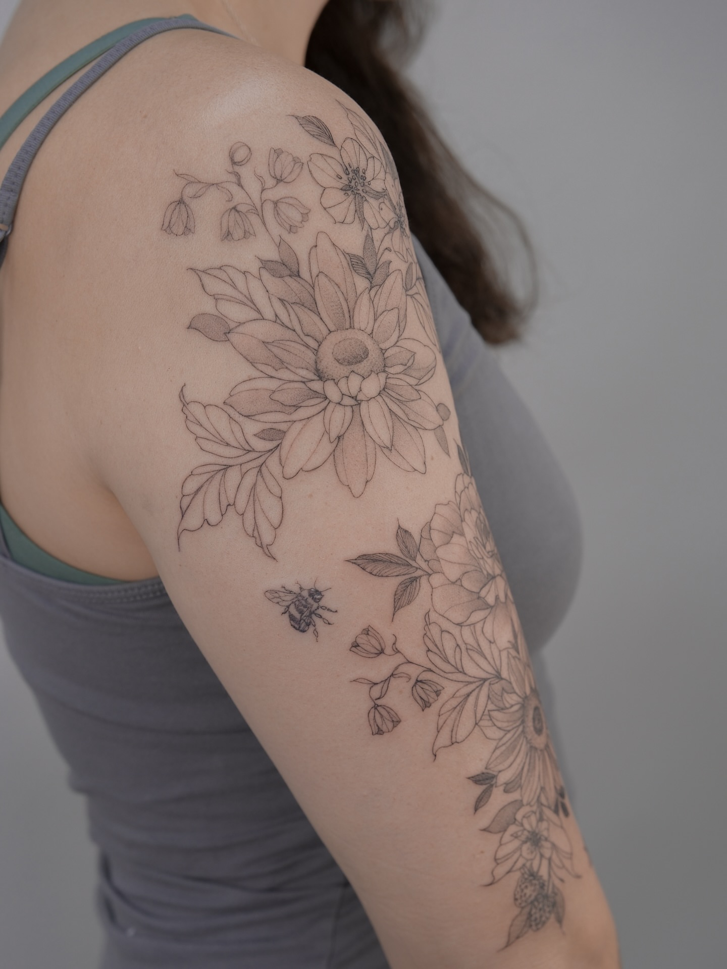 Flower bouquet with bee black and grey tattoo on the upper arm by Tattoo in Charlotte NC, Charlotte, North Carolina