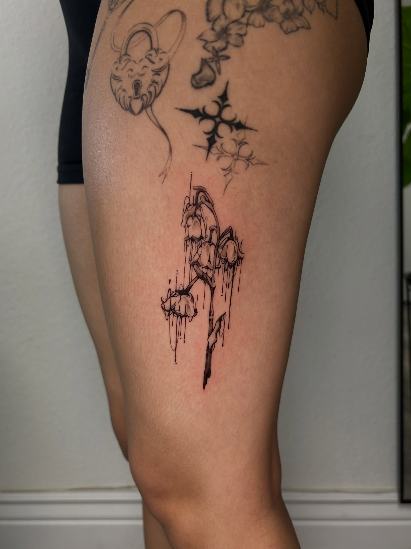 Flower and dripping liquid dotwork tattoo on the thigh by Miri