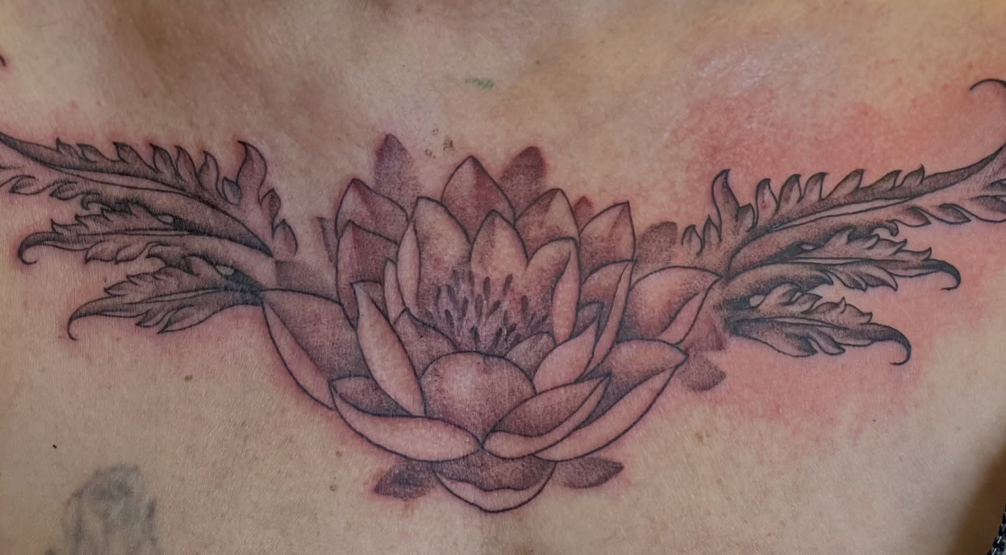 Lotus flower black and grey tattoo on the chest by Dani McBay