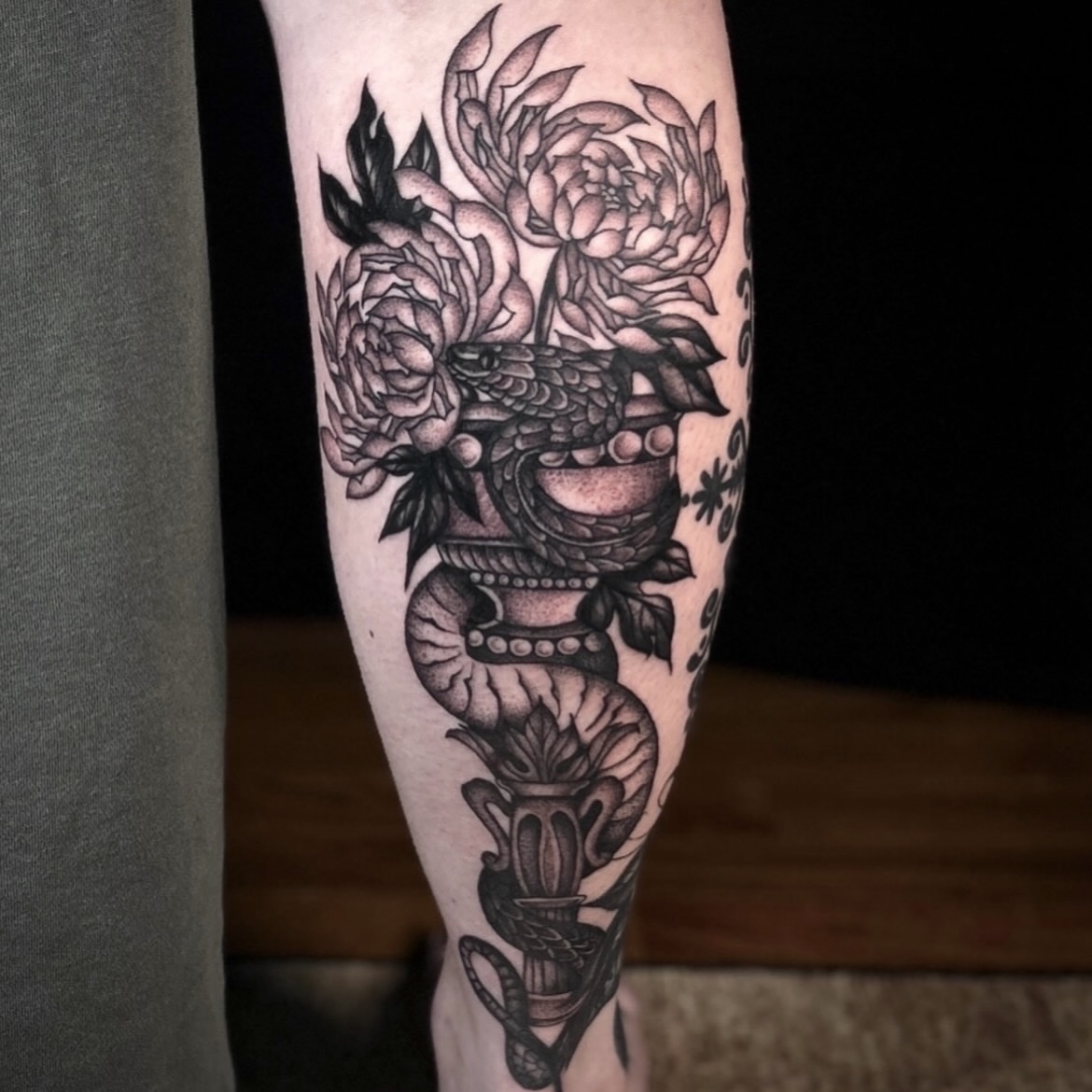 Snake and peony black and grey tattoo on the forearm by Kat McCoy Guidera, Nashville, Tennessee