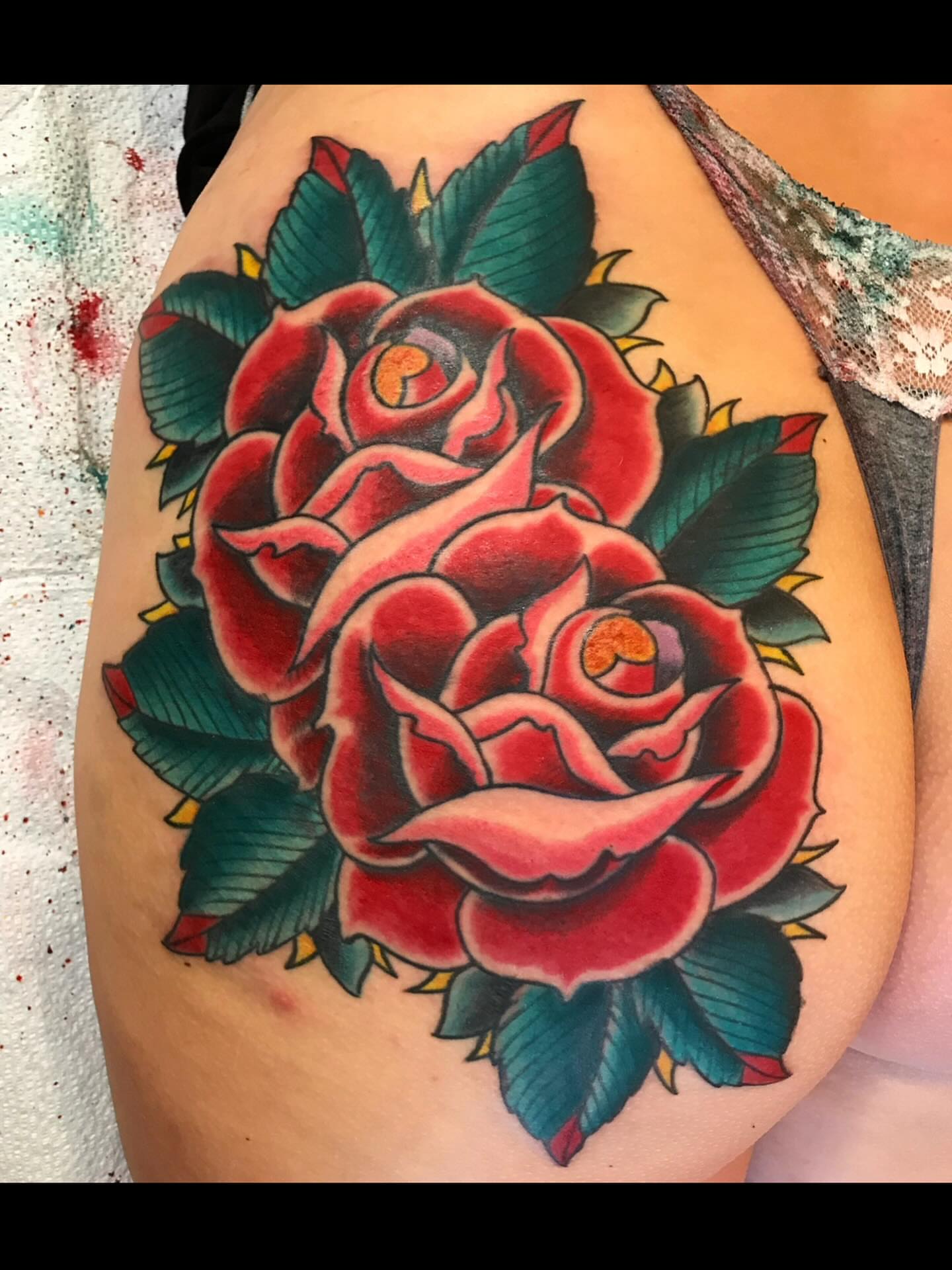 Red roses American traditional tattoo on the thigh by Mike Kepper