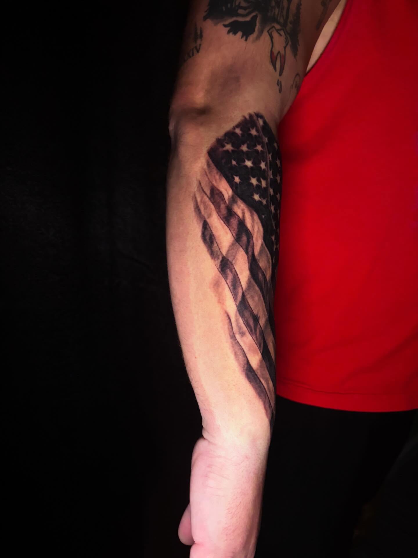 American flag black and grey tattoo on the forearm by Nicholas A. Estes-Davis