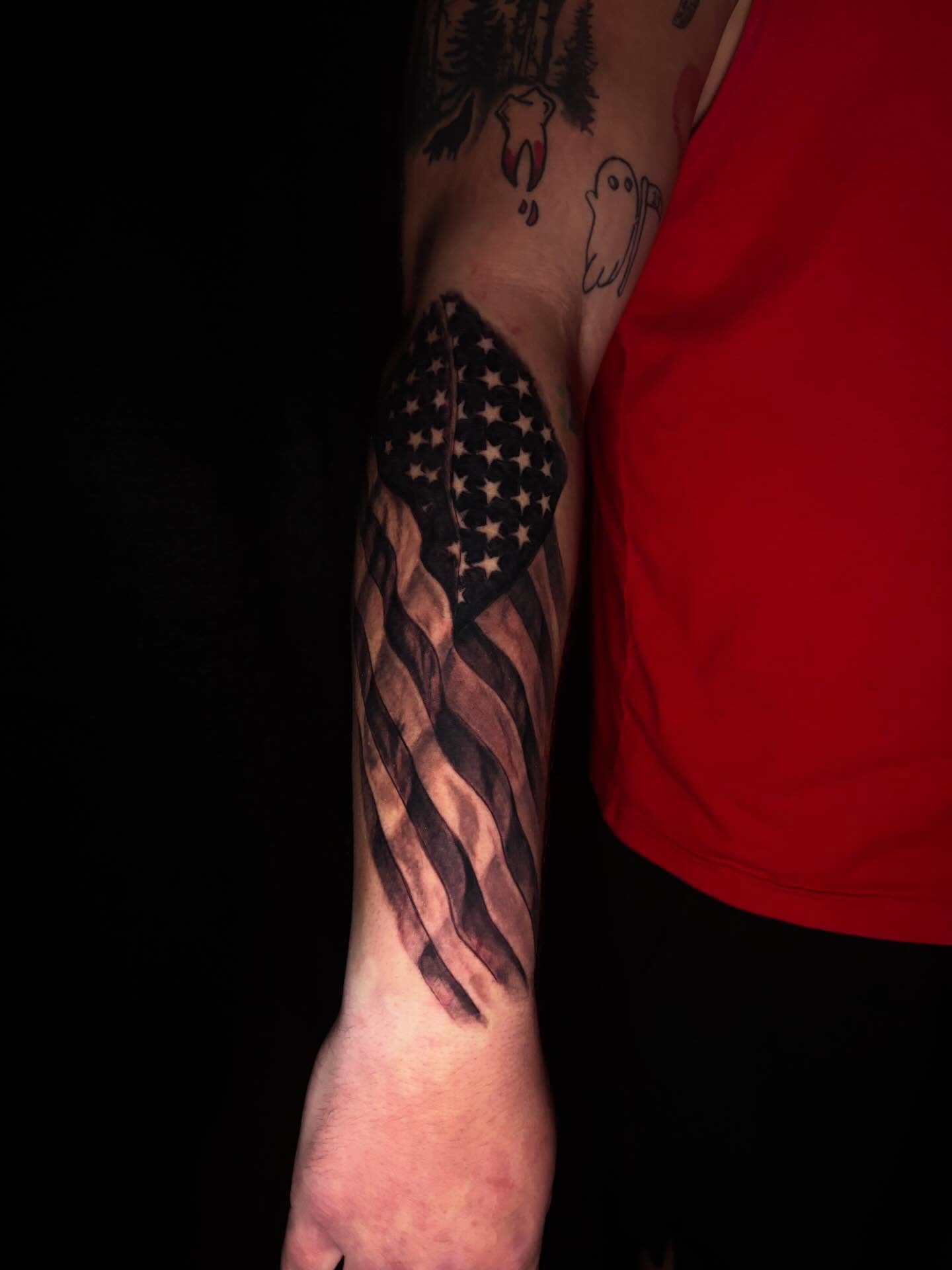 American flag black and grey tattoo on the forearm by Nicholas A. Estes-Davis