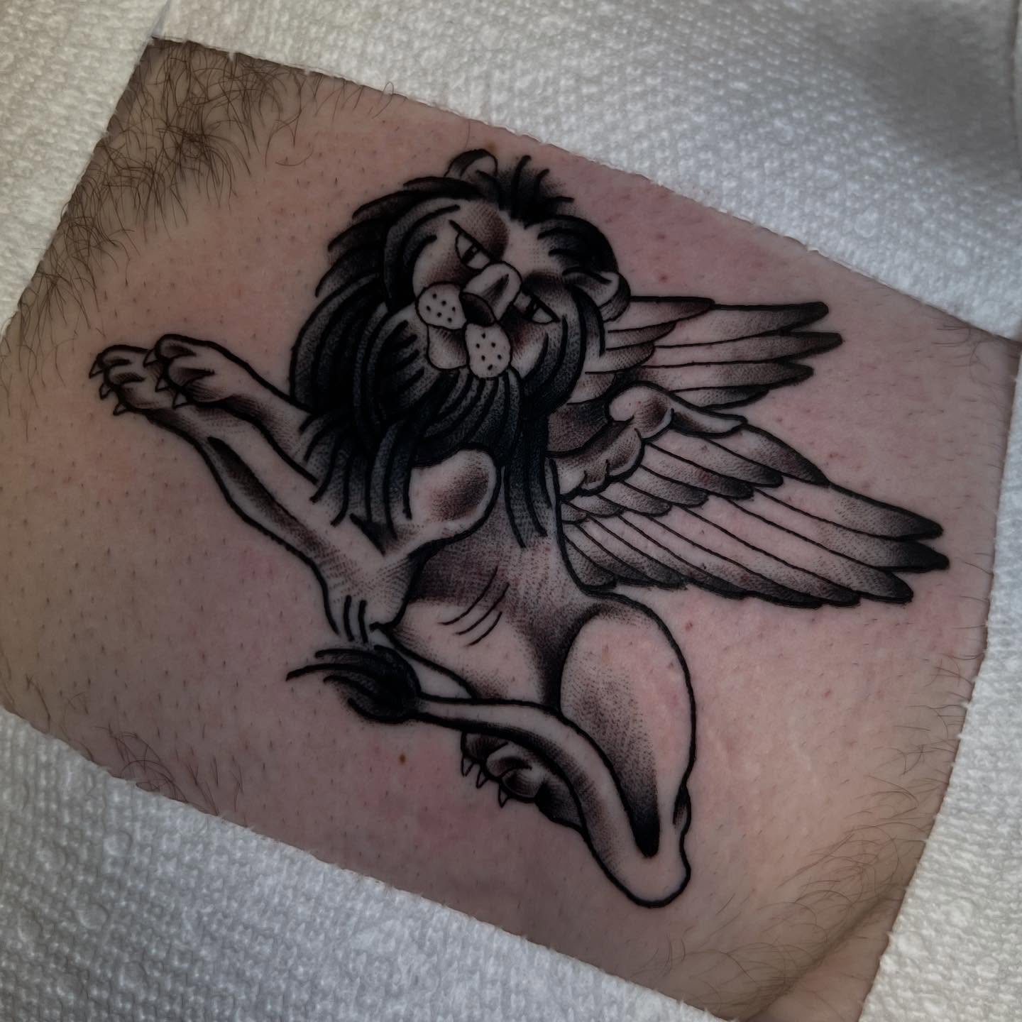 Lion with wings black and grey tattoo on the forearm by Katie Ann Tattoos