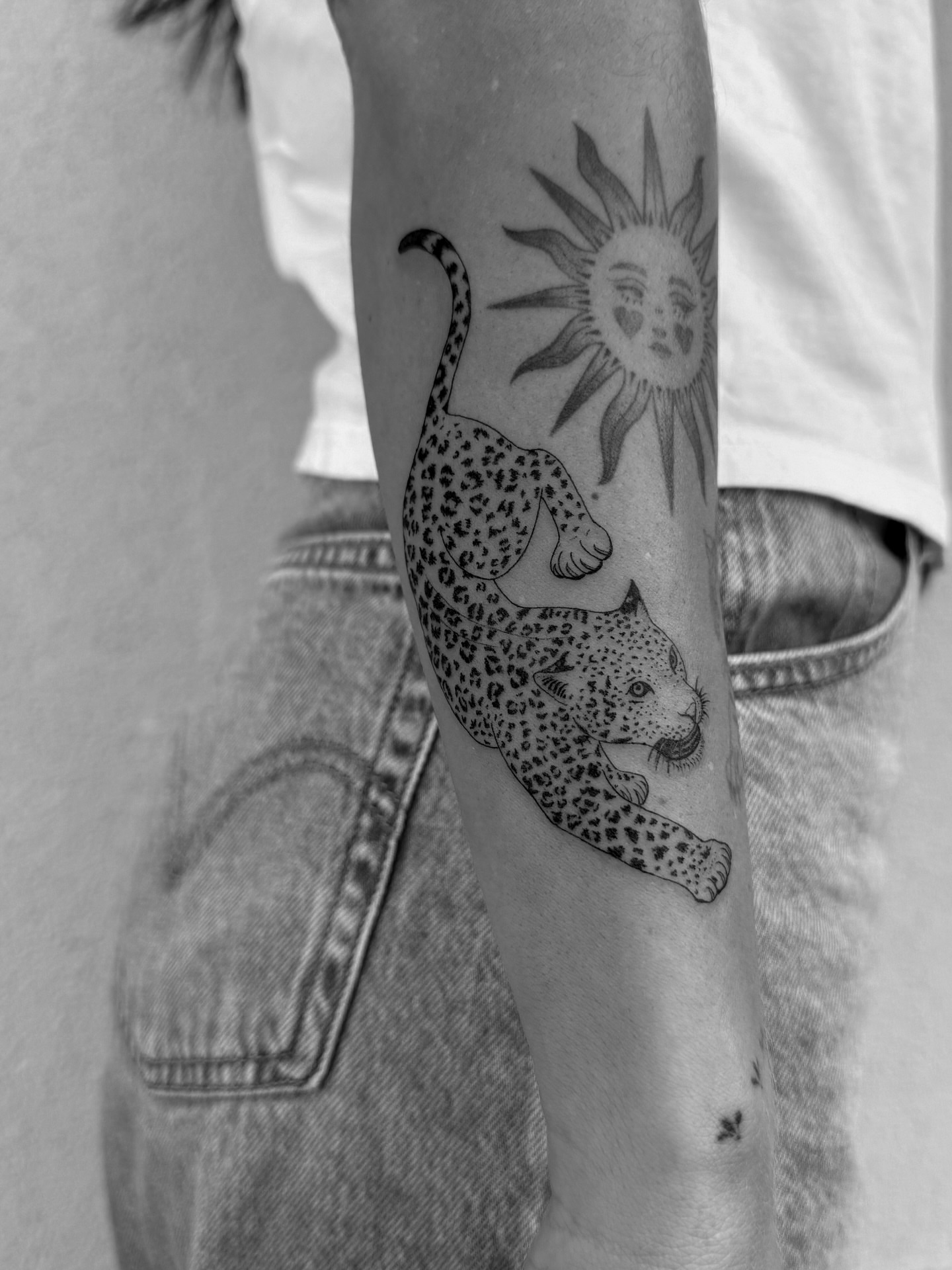 Leopard and sun realism tattoo on the forearm by Abby Robinson