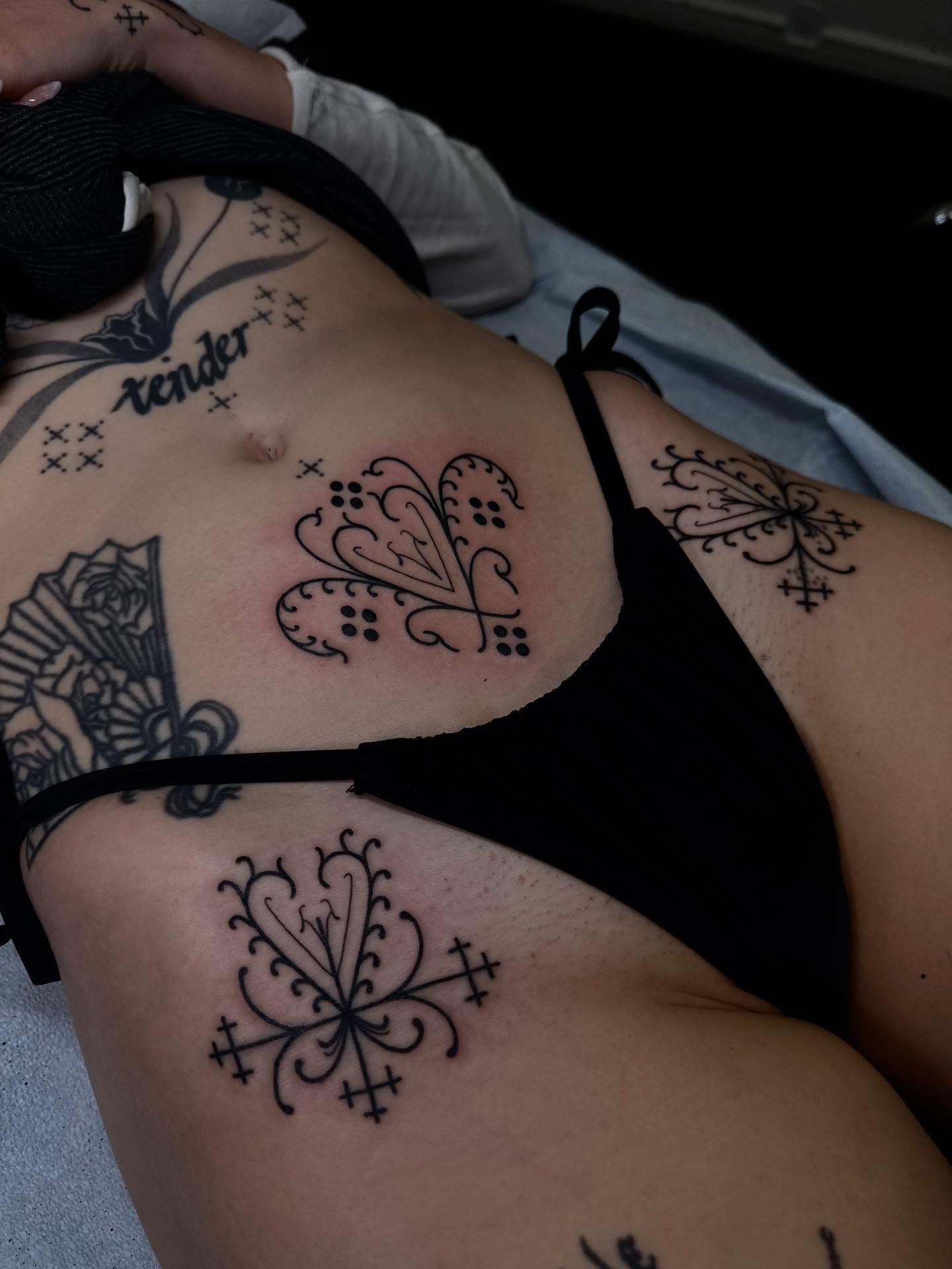 Floral motifs ornamental tattoo on the torso by Erin Shea