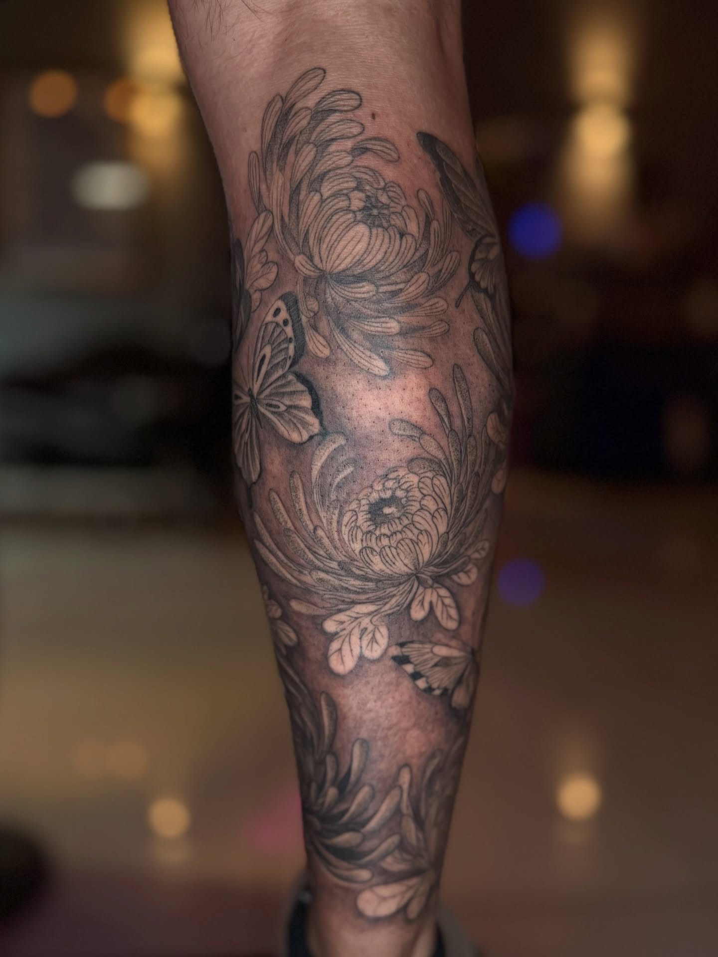 Chrysanthemums and butterflies black and grey tattoo on the forearm by B o n d B o n d , “ a r t i s t “