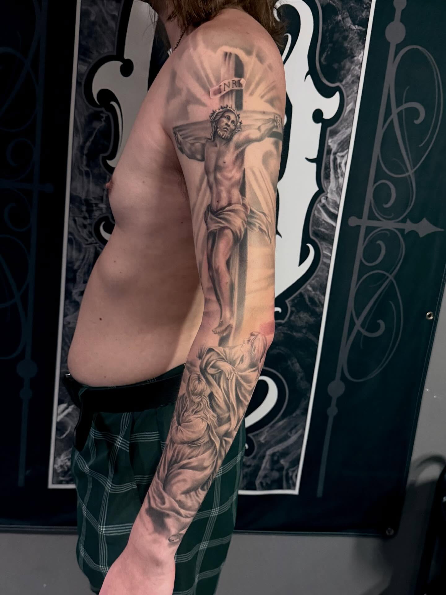 Religious crucifixion scene realism tattoo on the upper arm by Cody Pappas