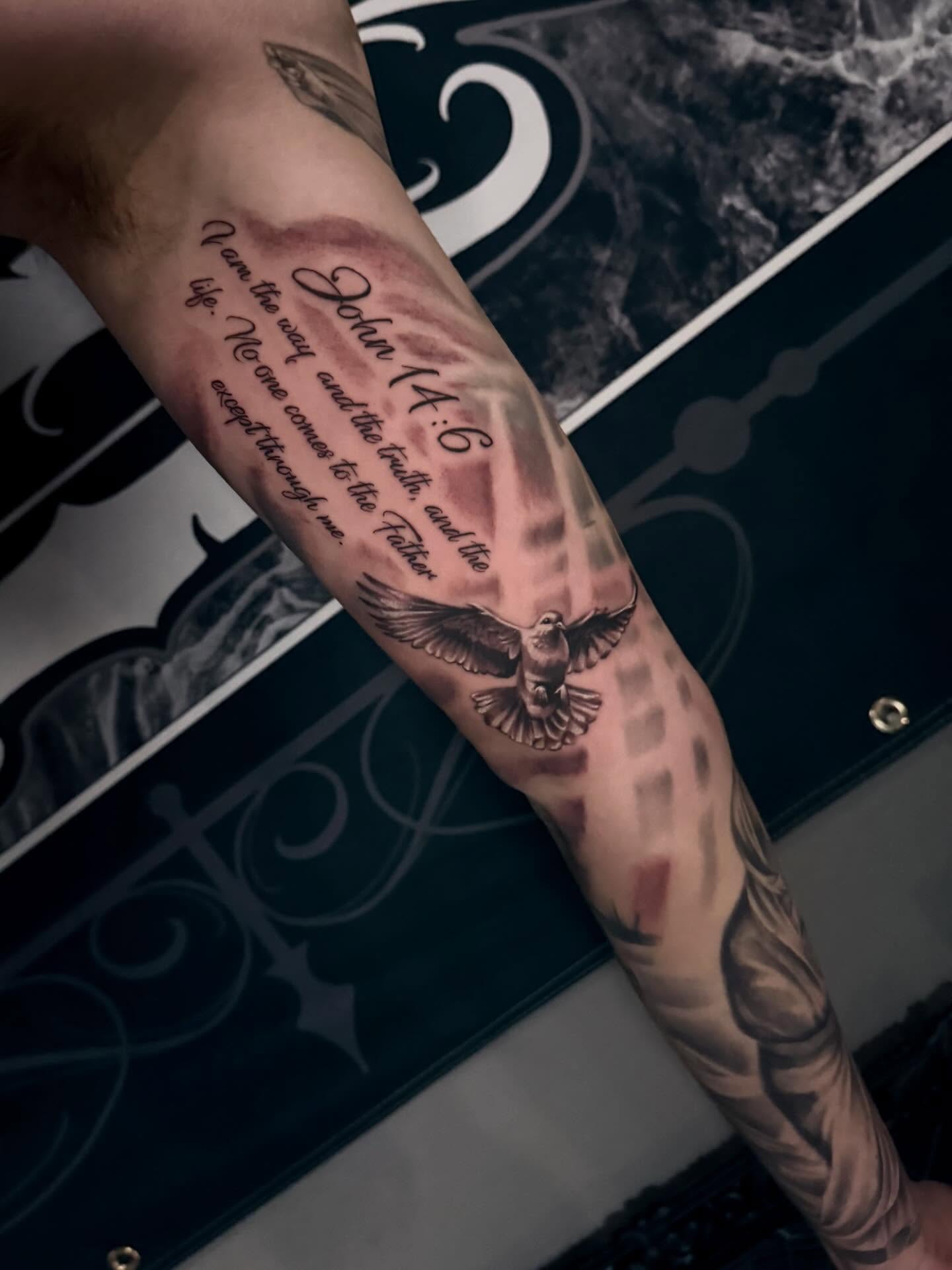 Eagle and biblical verse black and grey tattoo on the forearm by Cody Pappas
