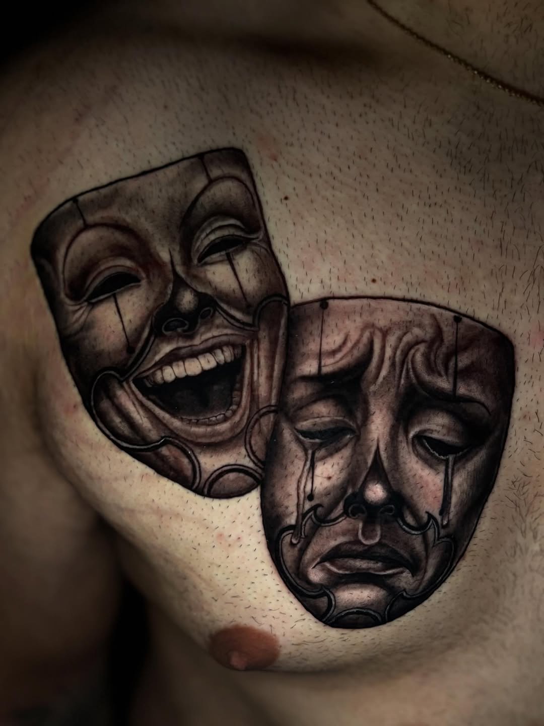 Comedy and tragedy masks realism tattoo on the chest by @_frankyvee