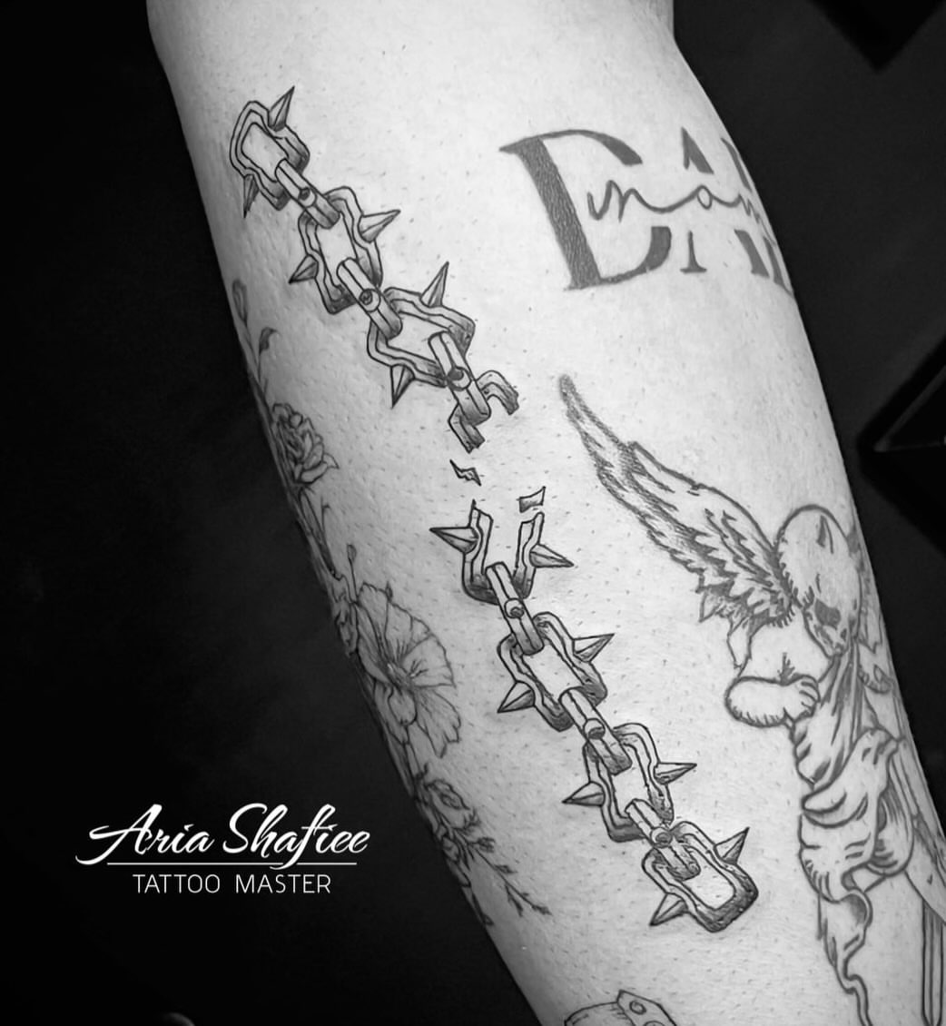 Chains and angel black and grey tattoo on the forearm by Aria Shafiee