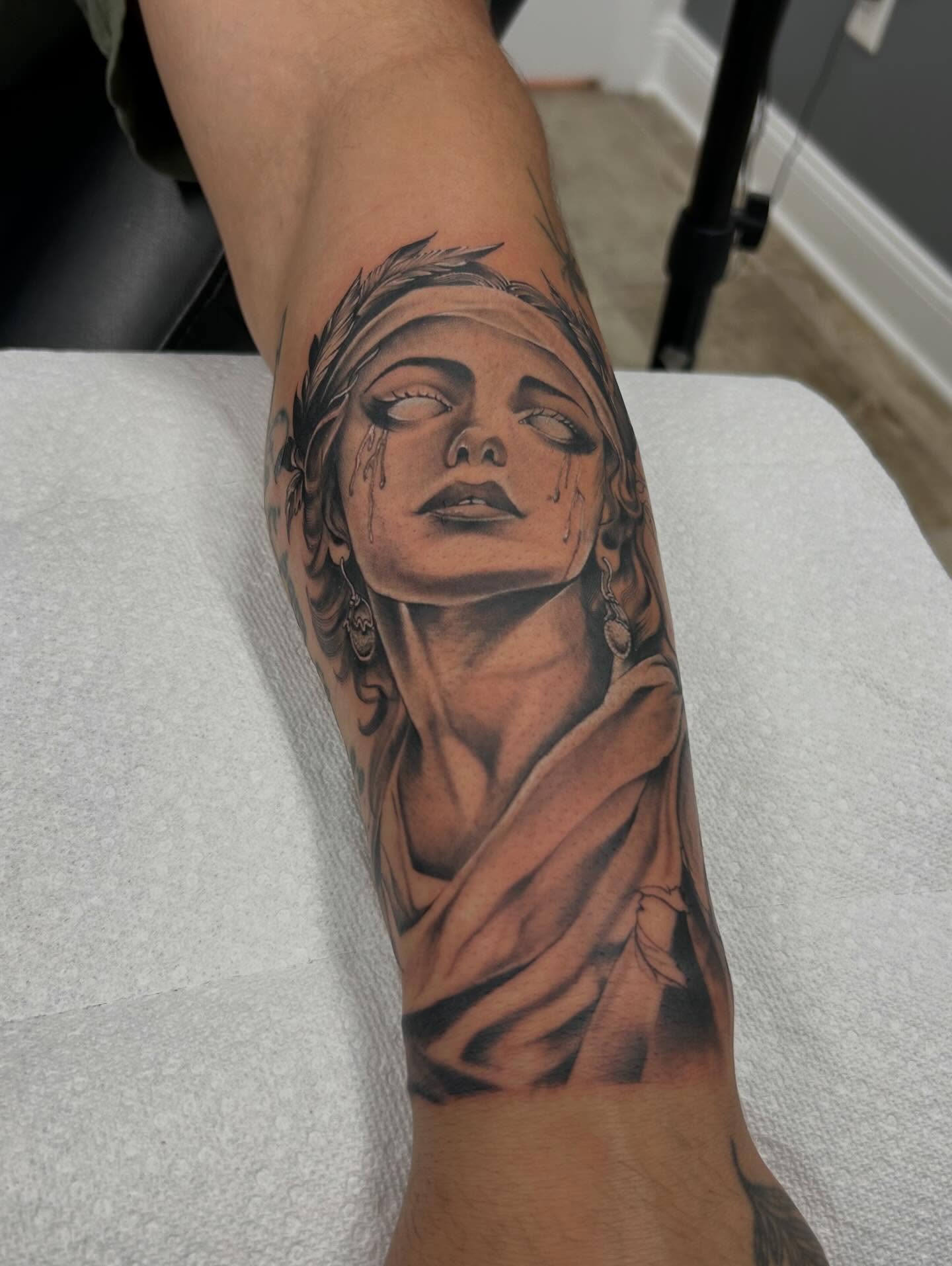 Woman with tears realism tattoo on the forearm by Denis Morello de Castro, South River, New Jersey