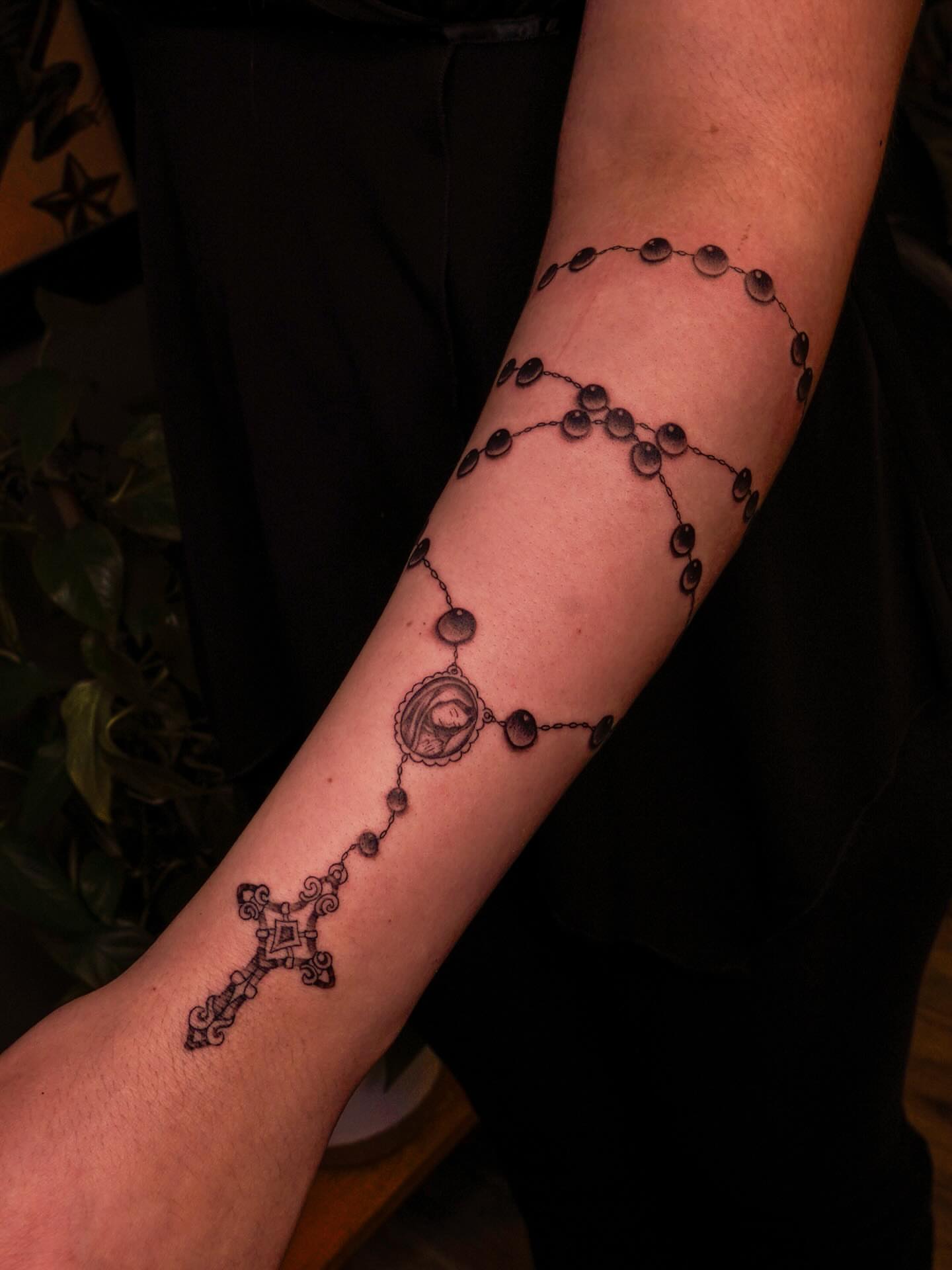 Rosary black and grey tattoo on the forearm by Nicki Yến