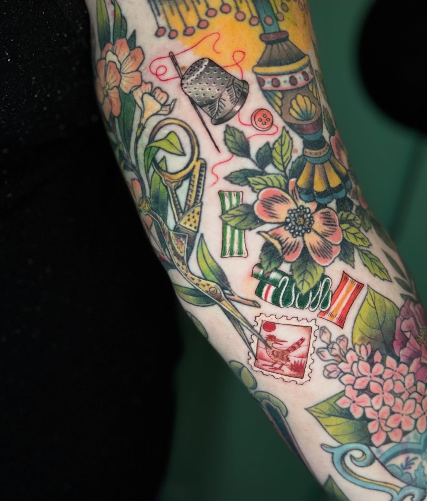 Sewing tools and flowers American traditional tattoo on the forearm by Katy Bisby