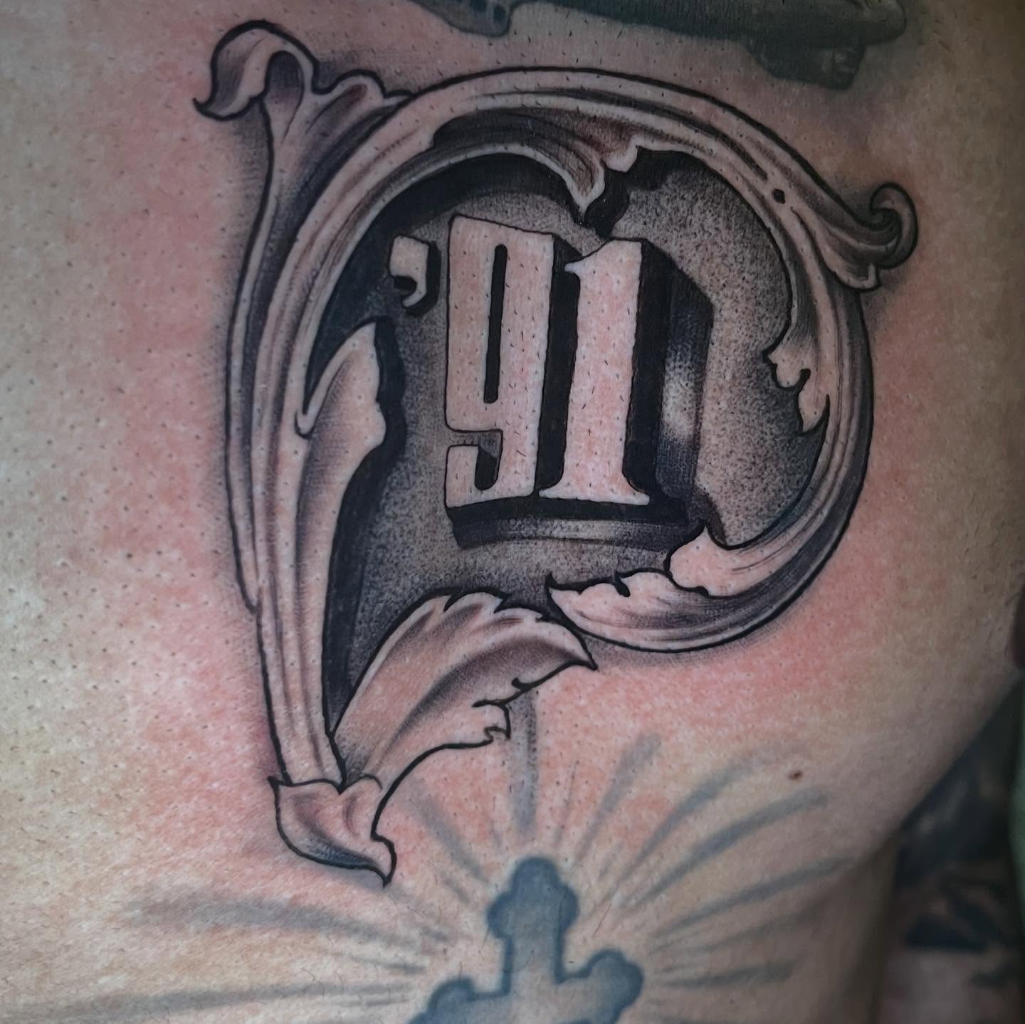 Number 91 black and grey tattoo on the chest by ATLANTA Queer Tattooer