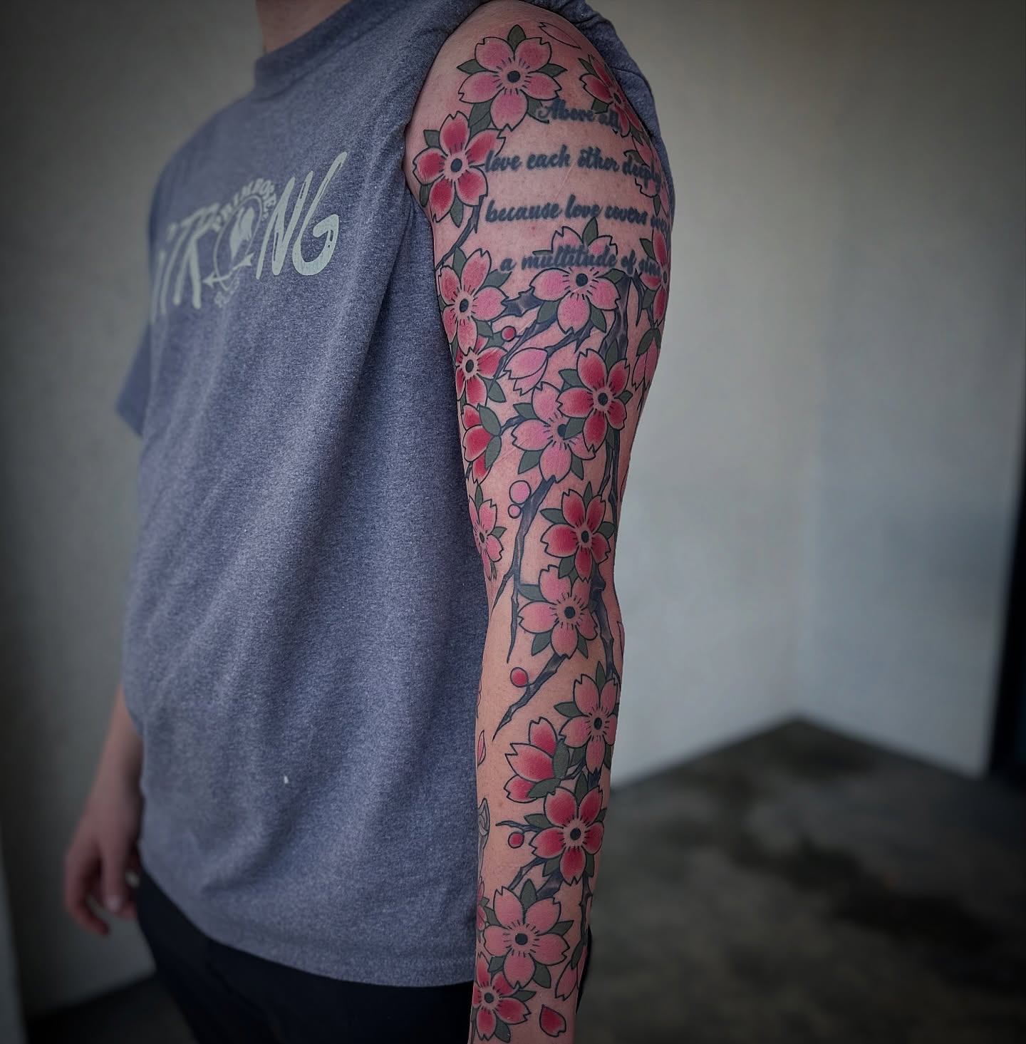 Cherry blossoms American traditional tattoo on the upper arm by Walk-in American Traditional Tattoos Las