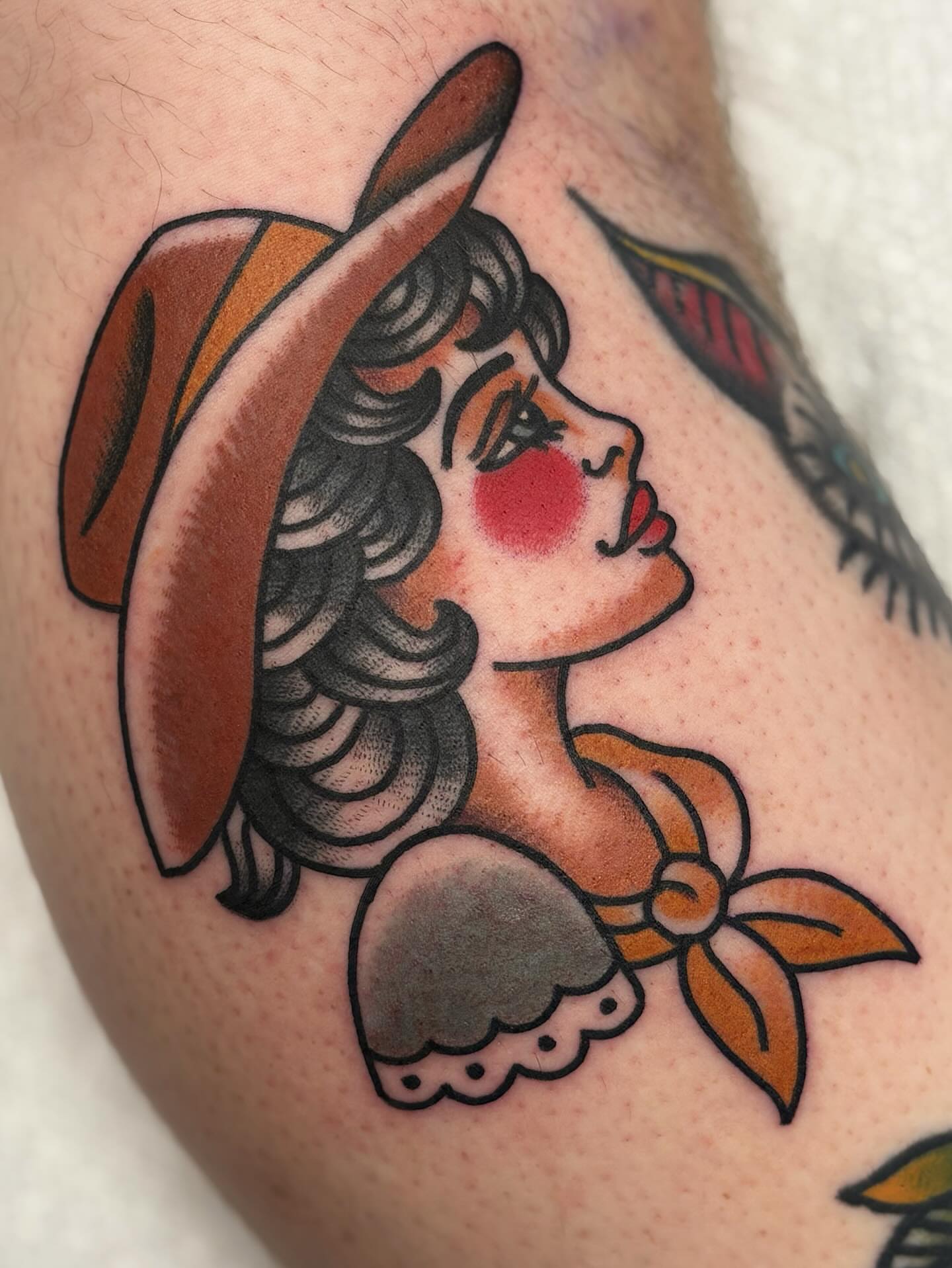 Woman wearing hat American traditional tattoo on the forearm by Dakota Amato
