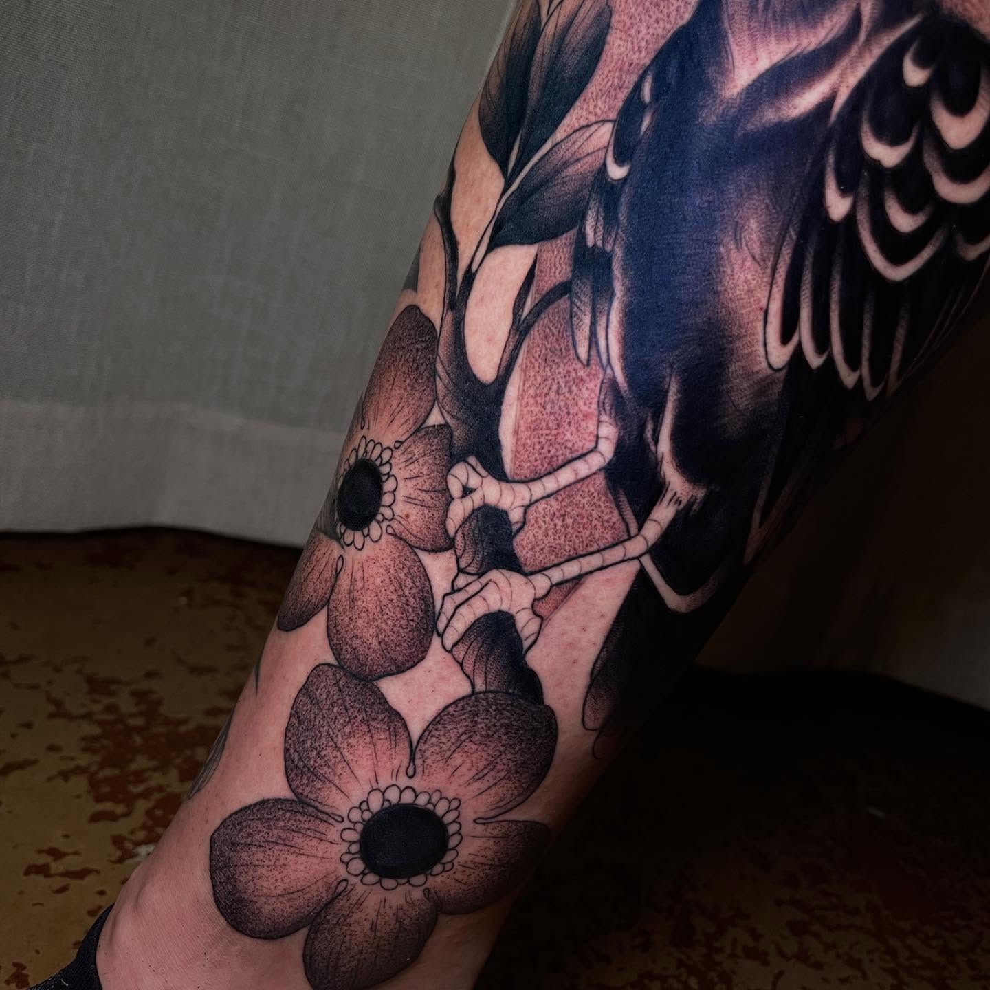 Flowers and skeleton dotwork tattoo on the forearm by Reagan Mauldin