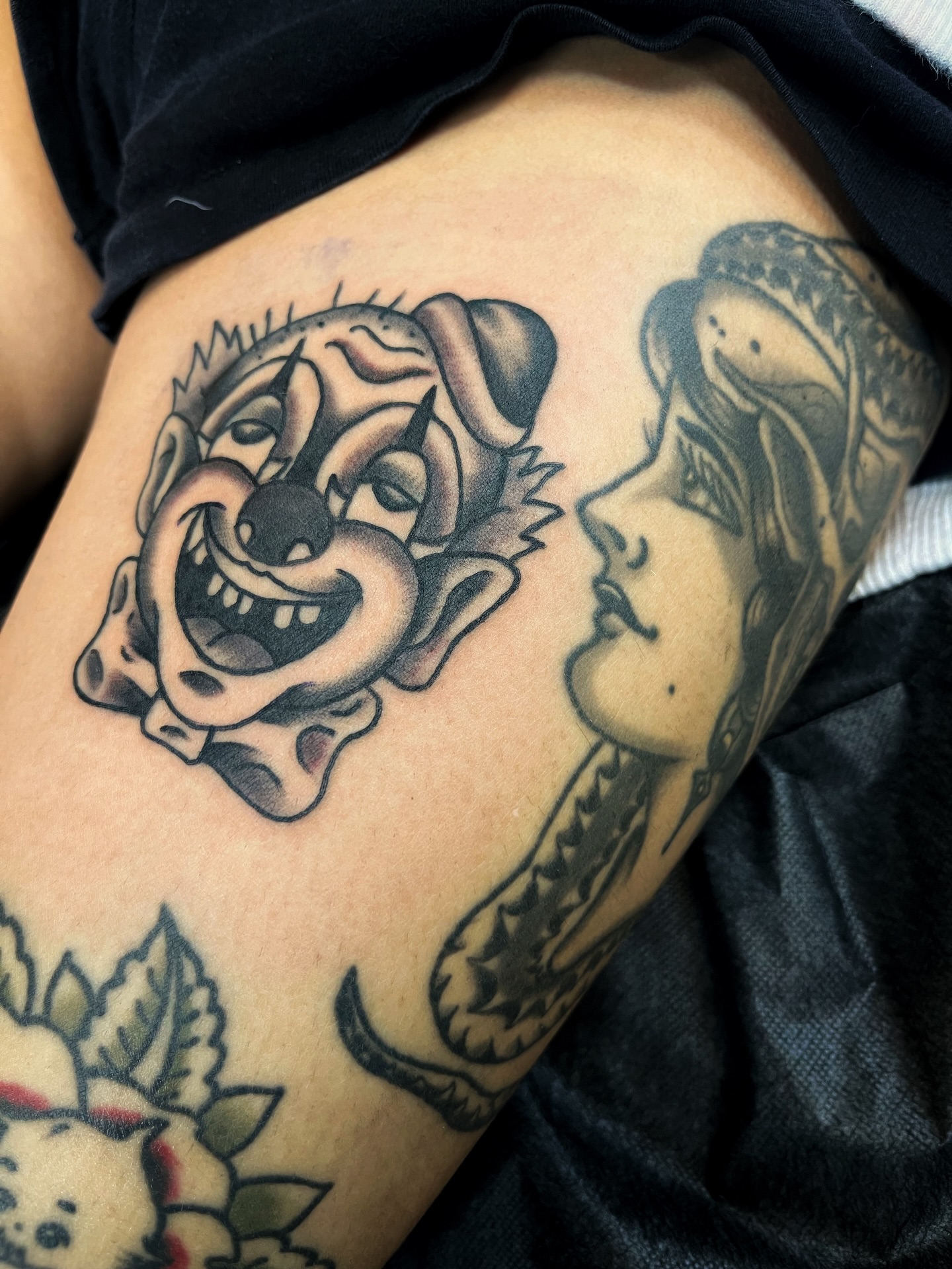 Clown and woman American traditional tattoo on the thigh by Gilbert Gonzalez